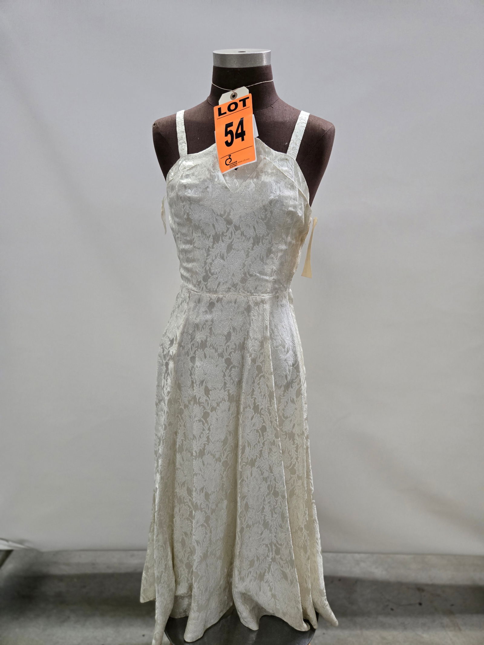 Cocktail dress, circa 1950s, white/silver floral brocade, side zip, by John Doyle Bishop.: Cocktail dress, circa 1950s, white/silver floral brocade, side zip, by John Doyle Bishop. IMPORTANT NOTE TO BIDDERS: We are not an auction gallery but a liquidator retained by CRC as they wind-down op