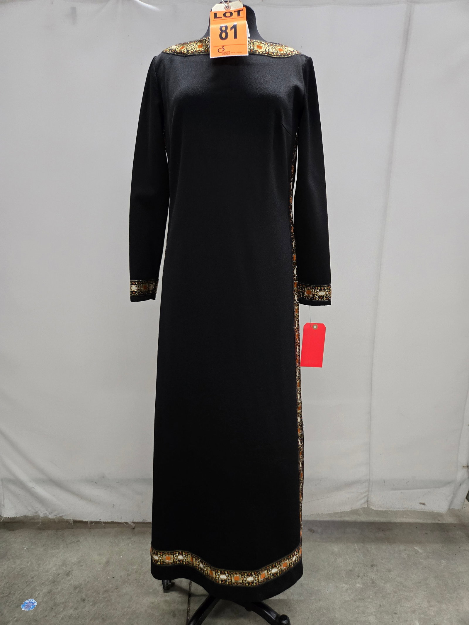 Gown, 1960s, black poly, orange/cream/metallic-gold border trim, by R & K Knits.: Gown, 1960s, black poly, orange/cream/metallic-gold border trim, by R & K Knits. IMPORTANT NOTE TO BIDDERS: We are not an auction gallery but a liquidator retained by CRC as they wind-down operations.