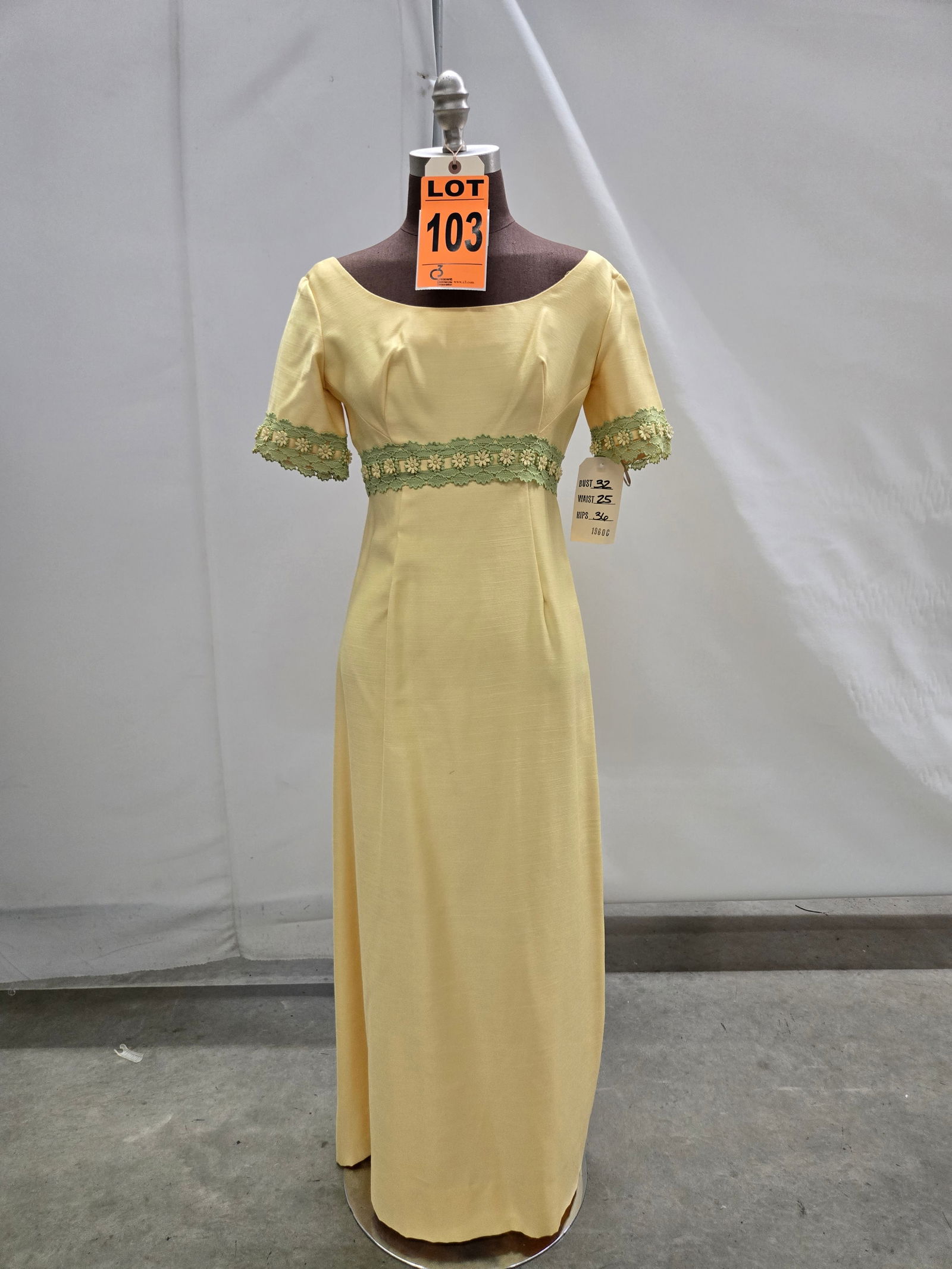 Evening gown, 1960s, yellow cotton, empire waist with green/yellow daisy trim.: Evening gown, 1960s, yellow cotton, empire waist with green/yellow daisy trim. IMPORTANT NOTE TO BIDDERS: We are not an auction gallery but a liquidator retained by CRC as they wind-down operations. A