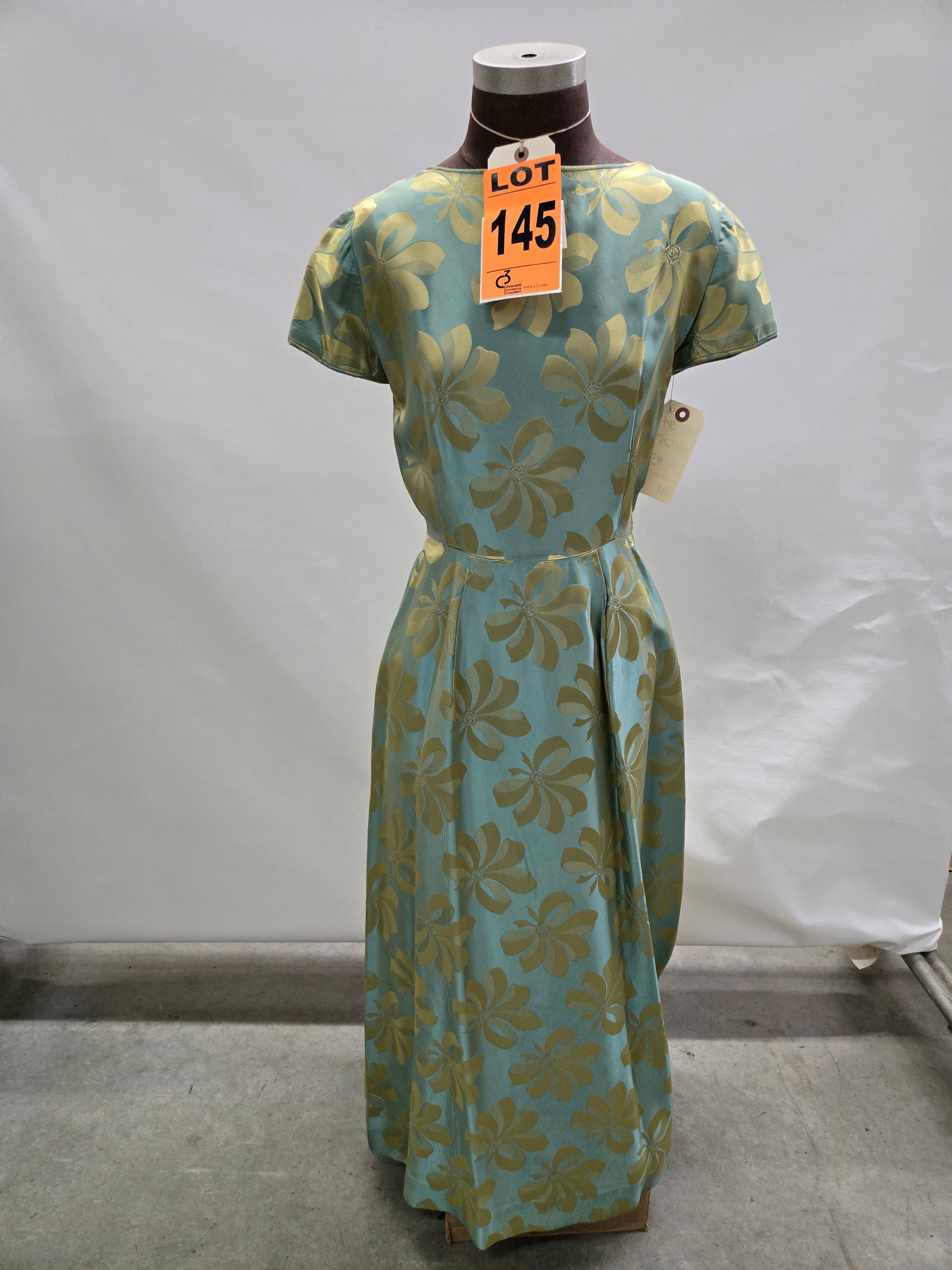 Evening gown, 1960s, teal/gold iridescent, large gold-bow pattern with attached belt.: Evening gown, 1960s, teal/gold iridescent, large gold-bow pattern with attached belt. IMPORTANT NOTE TO BIDDERS: We are not an auction gallery but a liquidator retained by CRC as they wind-down operat