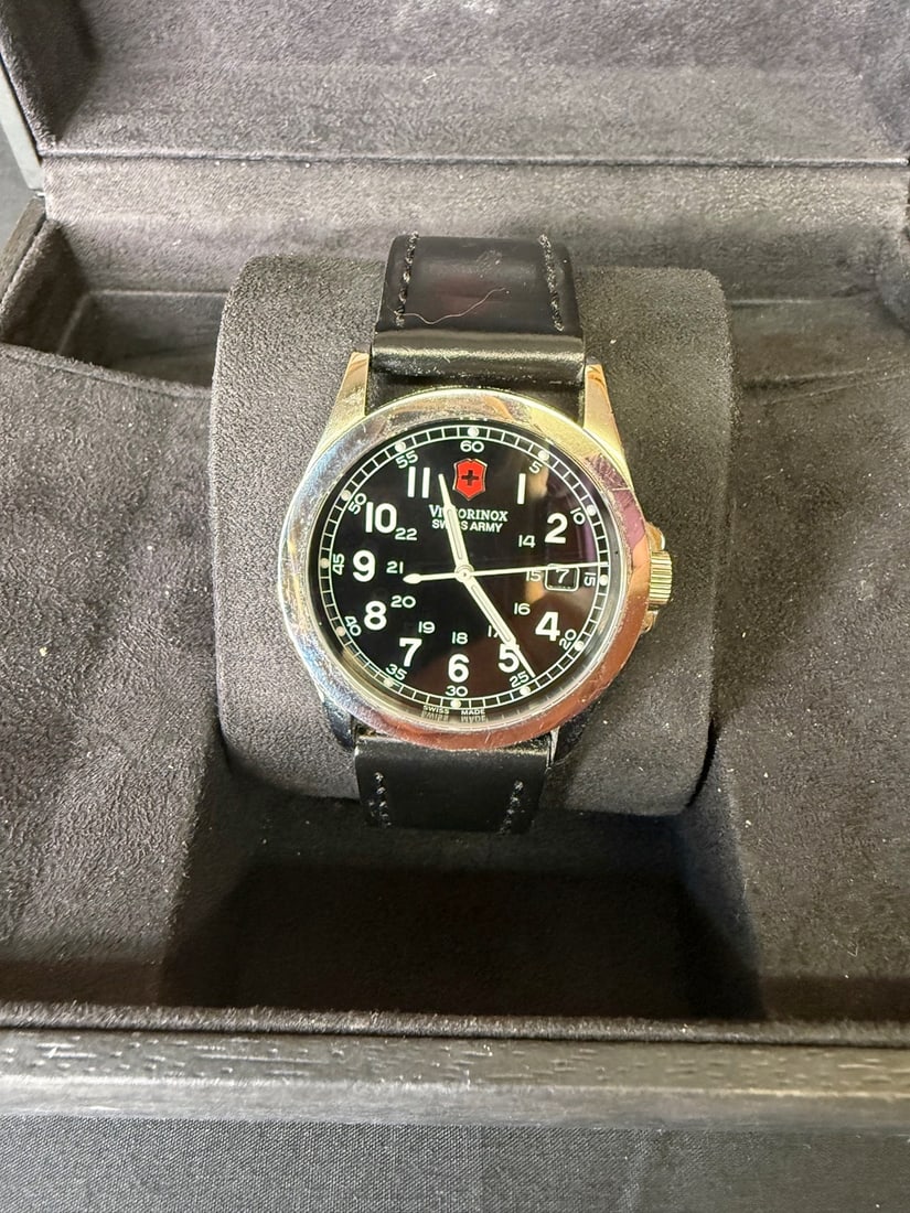 Victorinox Infantry: 41mm case diameter including crown with a black dial, white hourly numbers and silver and white hands and a polished silver bezel. Case back inscription STAINLESS STEEL WATER RESISTANT 100 METERS VICT