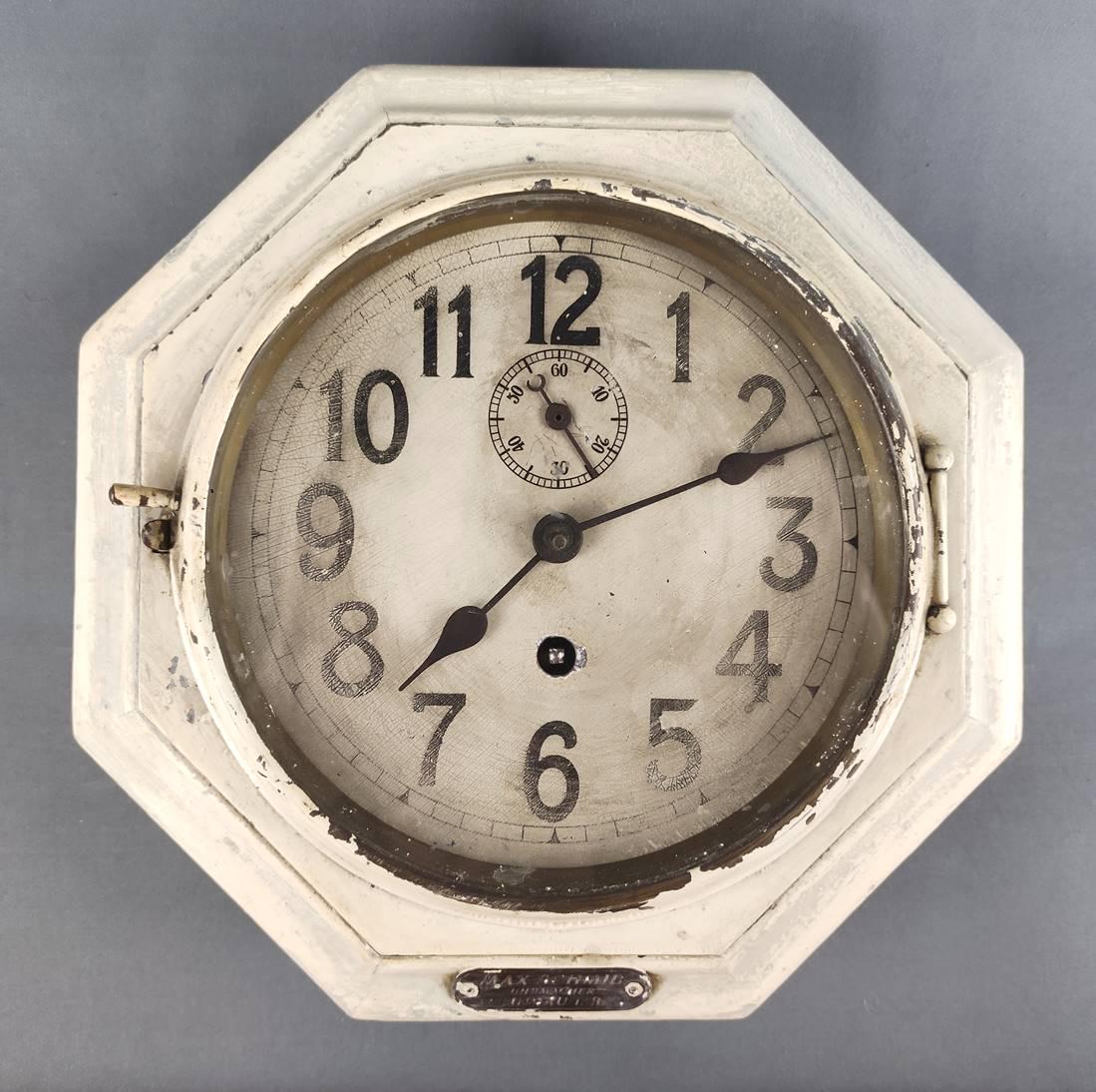 Wall clock "FÃ¤hre", octagonal wooden body painted white, round dial with Ar: Wall clock "FÃ¤hre", octagonal wooden body painted white, round dial with Arabic numerals, at number 12 small second, winding with key (enclosed), starts, inscribed "FÃ¤hre" on the back, front wit