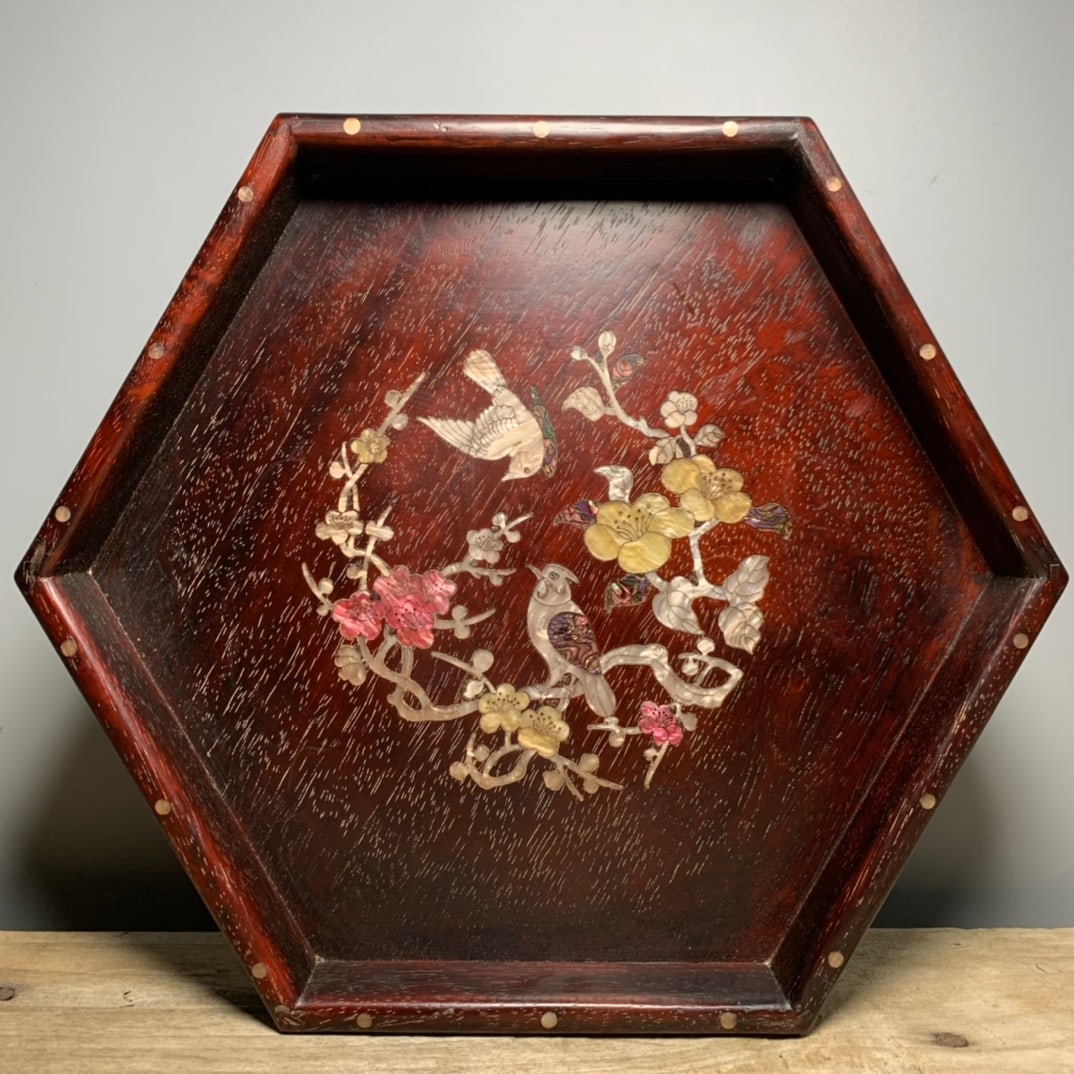 Hexagonal tea tray with small-leaf red sandalwood inlaid with shells and magpies climbing on plum: Hexagonal tea tray with shells and magpies climbing on plum blossoms inlaid with small-leaf red sandalwood, with obvious cow hair pattern. 35cm long, 30cm high, 4cm thick Provenance:Private collection