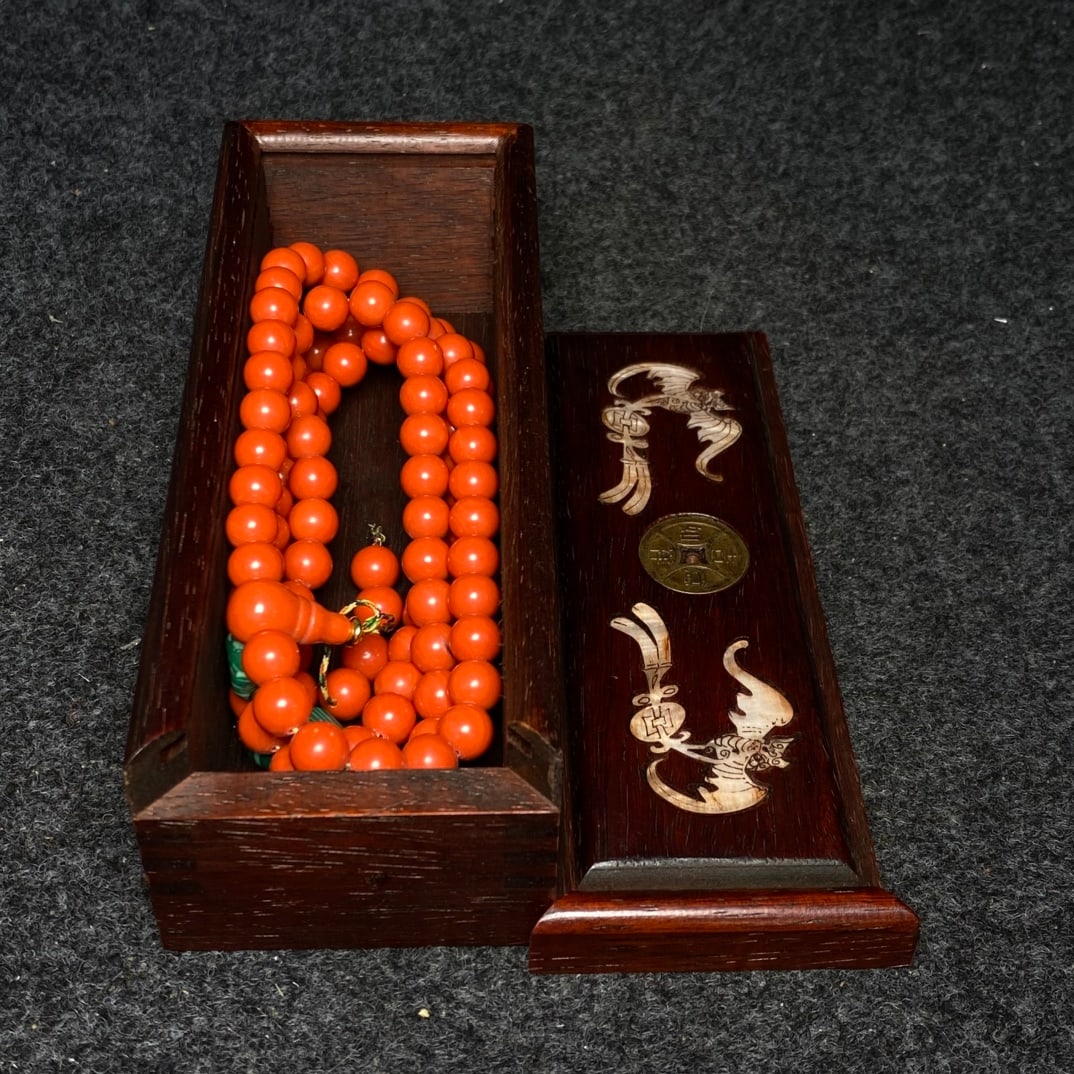 A precious coral Buddhist prayer beads are housed inside a rosewood and mother-of-pearl inlaid box. (1 of 9)