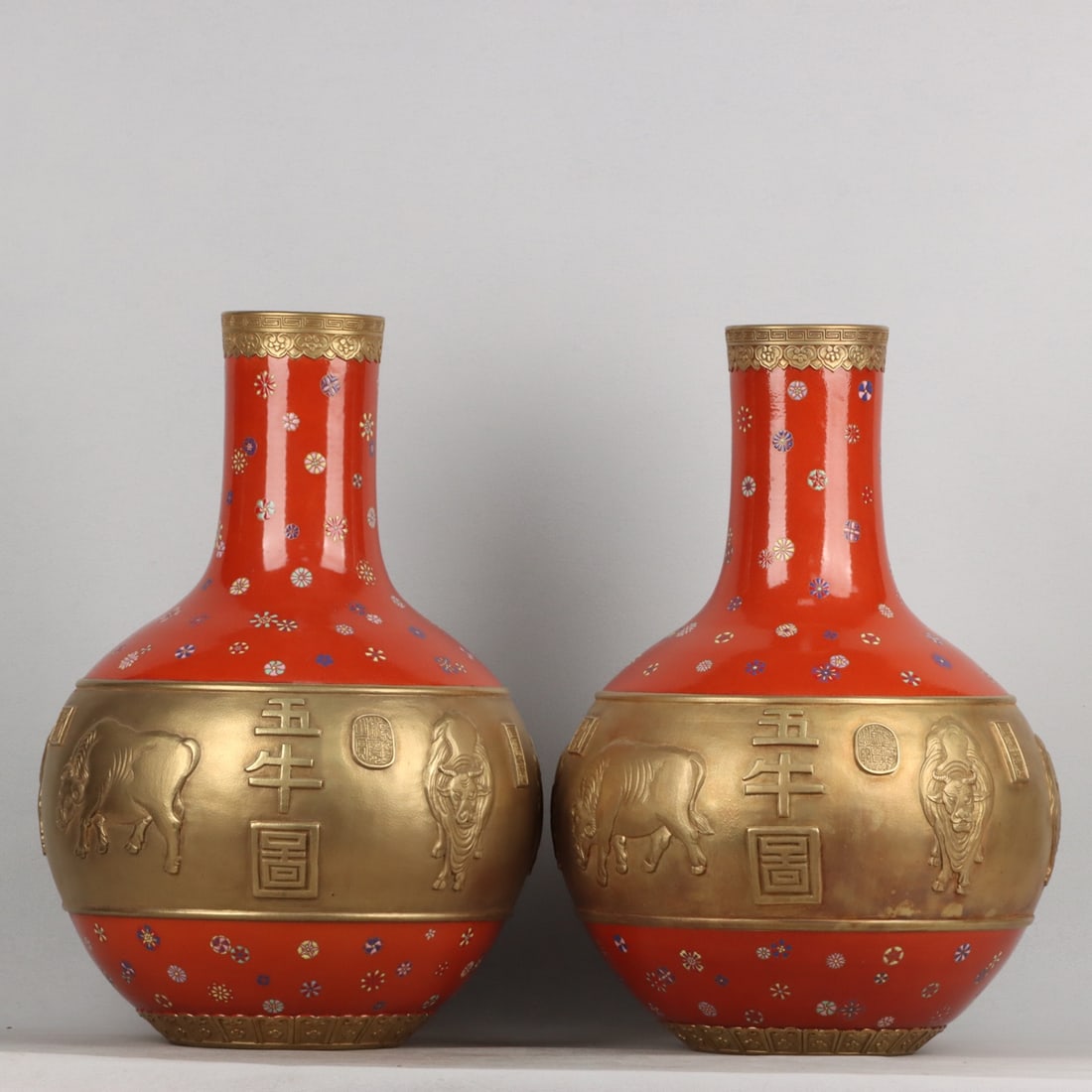 A red-ground gilt enamel vase with relief of five oxen, dating from the Qianlong period of the Qing: A pair of Qing Dynasty Qianlong period red-ground gilt enamel relief five-oxen celestial globe vases, 59 x 39 cm high and wide. Provenance:Private collection from a professor in Yale University. Our d