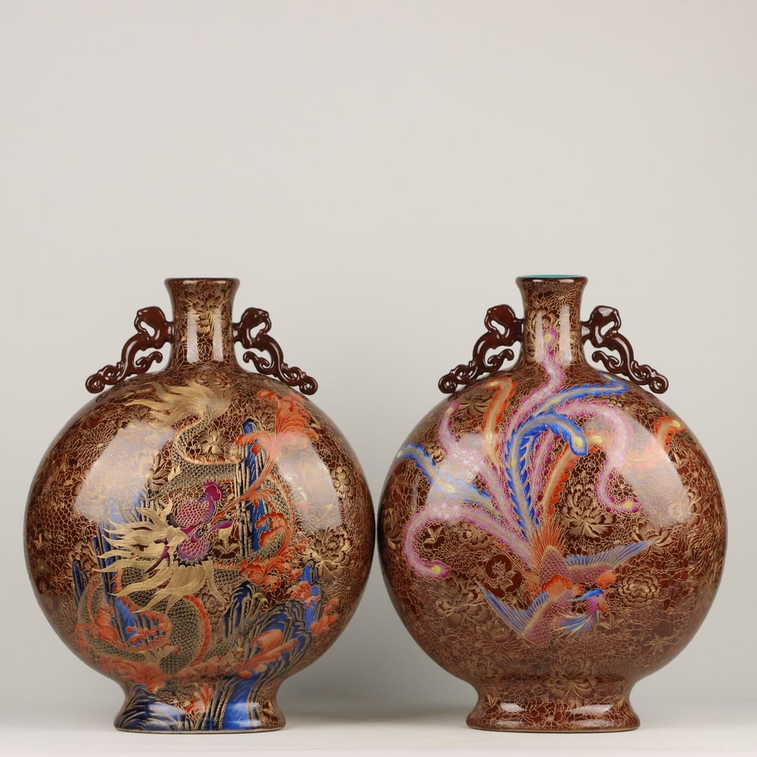 A Qianlong period famille rose enamel moon flask with cloisonne enamel and gold wire dragon and: A pair of Qing Dynasty Qianlong period enamel-painted moon flasks with cloisonne dragon and phoenix designs, each measuring 50 x 38 cm. Provenance:Mr. Jacob, Maryland. Inherited from his father. Our d