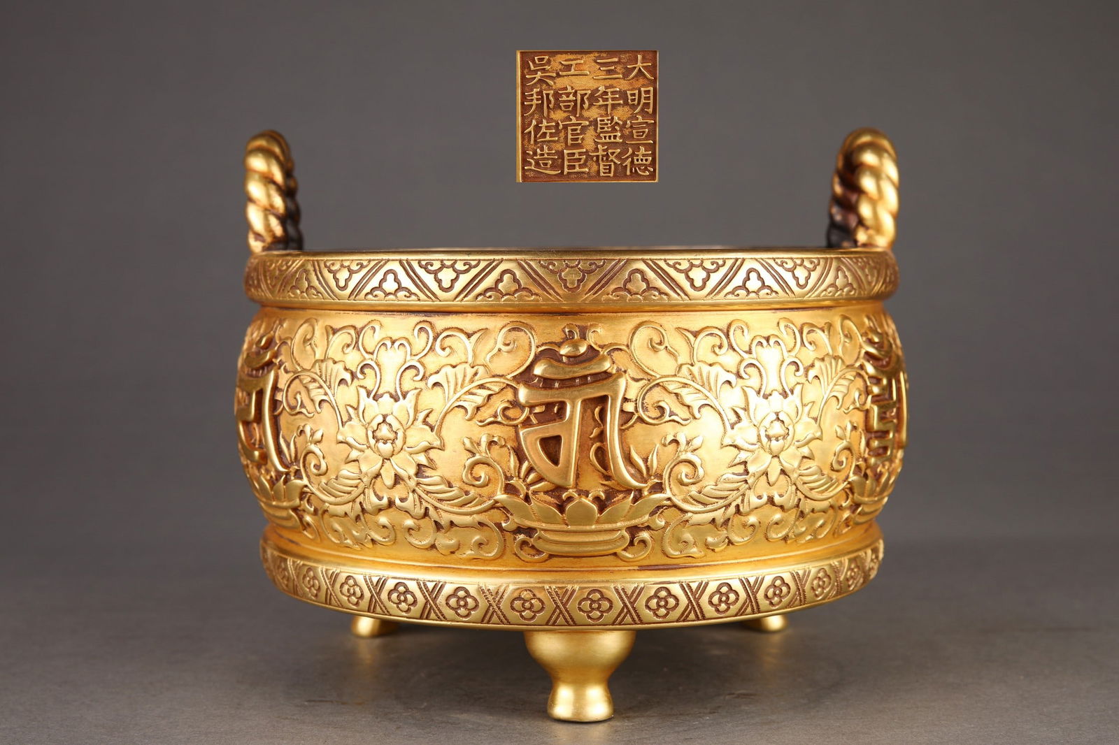 Ming Dynasty Finely Cast Purple Copper Gilt Lotus Pattern Drum-Shaped Incense Burner: A finely cast, gilt bronze censer with lotus scroll design and drum-shaped handles, dating from the Ming Dynasty. Dimensions: Height 16.5cm, Mouth Diameter 19.6cm, Belly Diameter 21.5cm. Inscription: