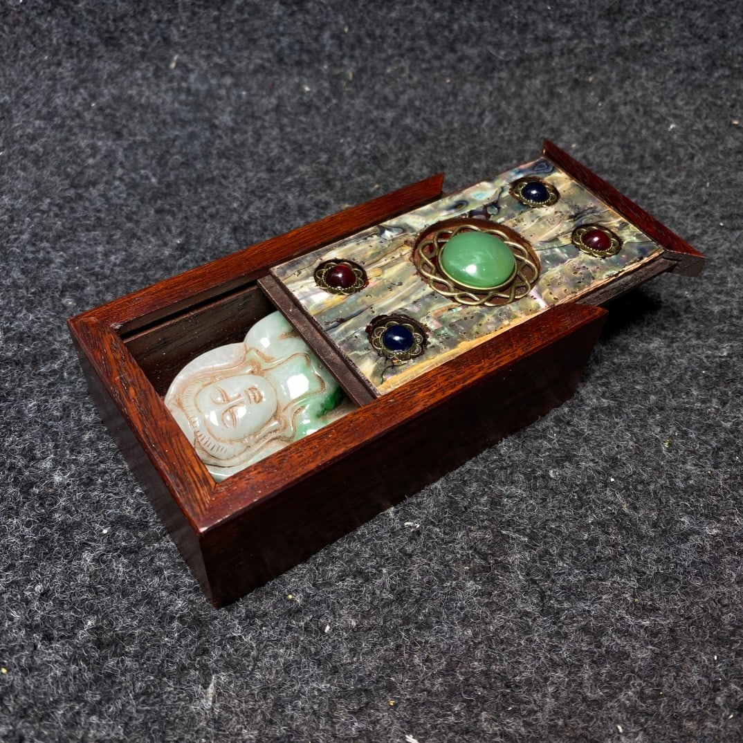 A rosewood box inlaid with mother-of-pearl contains a jade pendant. (1 of 9)