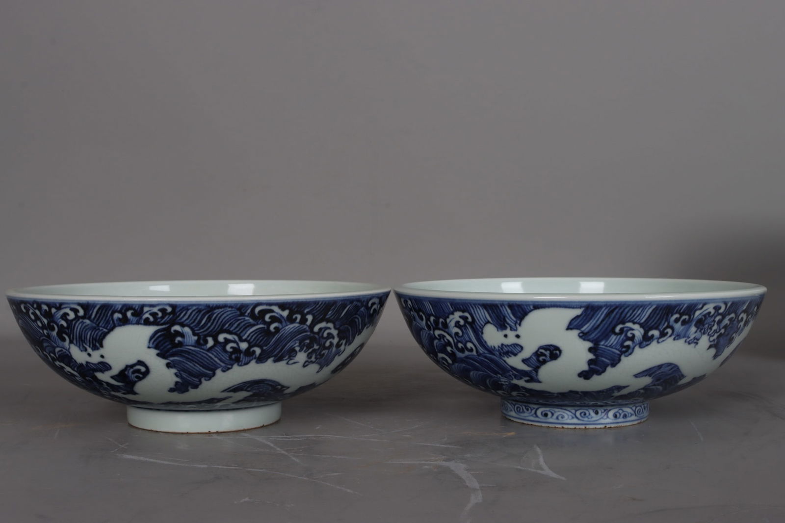 A pair of blue and white porcelain dice bowls with white dragon and wave design from the Xuande (1 of 9)