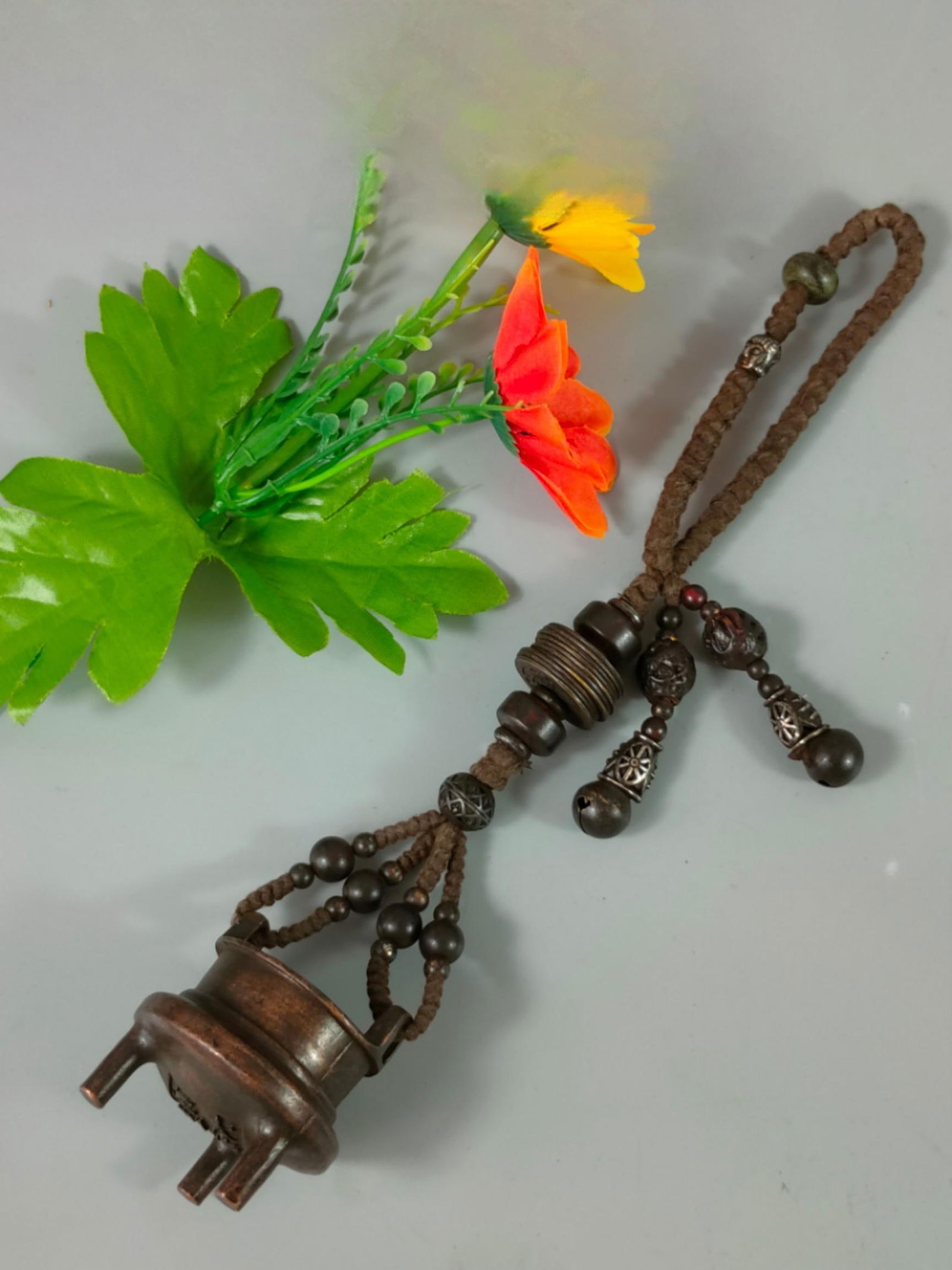 A Qing Dynasty bronze tripod censer with a jade and precious stone pendant.: A Qing dynasty bronze tripod censer with a jade and precious stone pendant. Mouth diameter 4.1 cm, belly diameter 5 cm, height 5.5 cm, total length 28 cm, weight 213 g. Provenance:Mr. Stefan, Minneapo