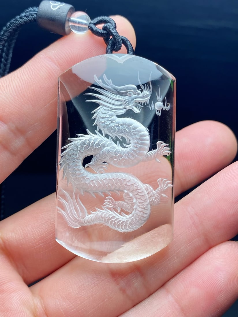 Natural white crystal "No Worries" pendant with dragon carving inside.: This natural white crystal "No Worries" pendant features an inner dragon carving. The crystal is clear, and the dragon, the foremost of the four auspicious creatures, symbolizes soaring ambition and t