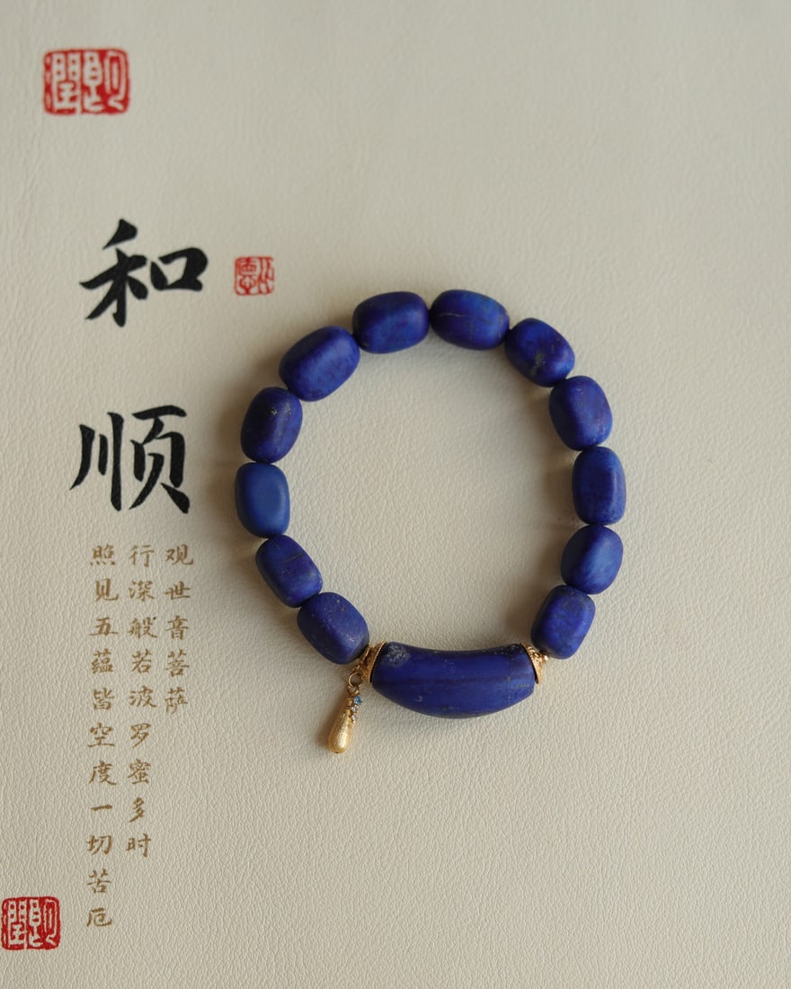 Natural lapis lazuli rough stone freeform bracelet: This natural lapis lazuli rough stone bracelet is approximately 9mm in size and features a natural lapis lazuli curved tube and sterling silver gilt teardrop-shaped embellishments, exuding a truly sim