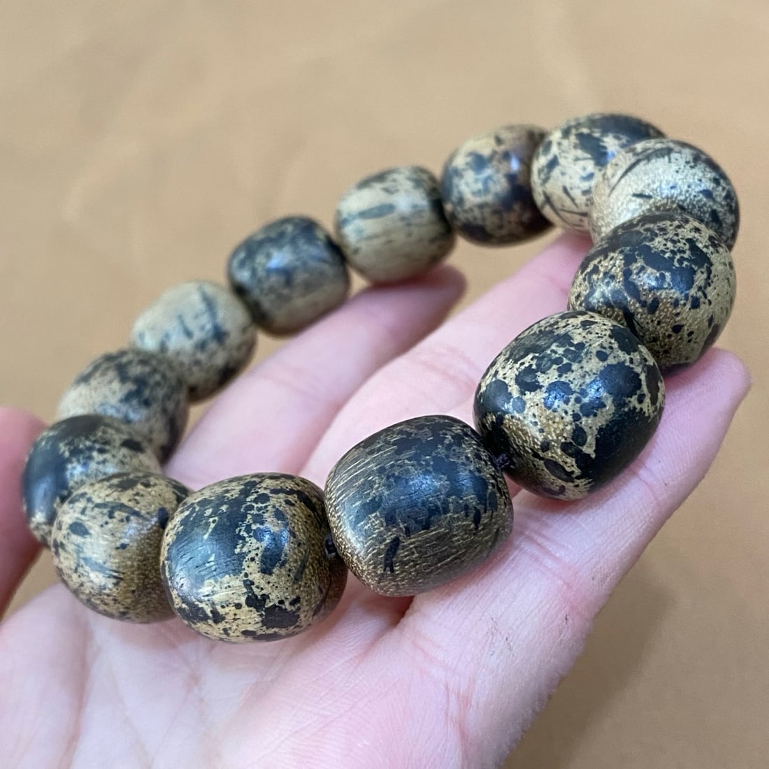 Agarwood bracelets and agarwood prayer bead necklaces are displayed in a brocade box. (1 of 9)