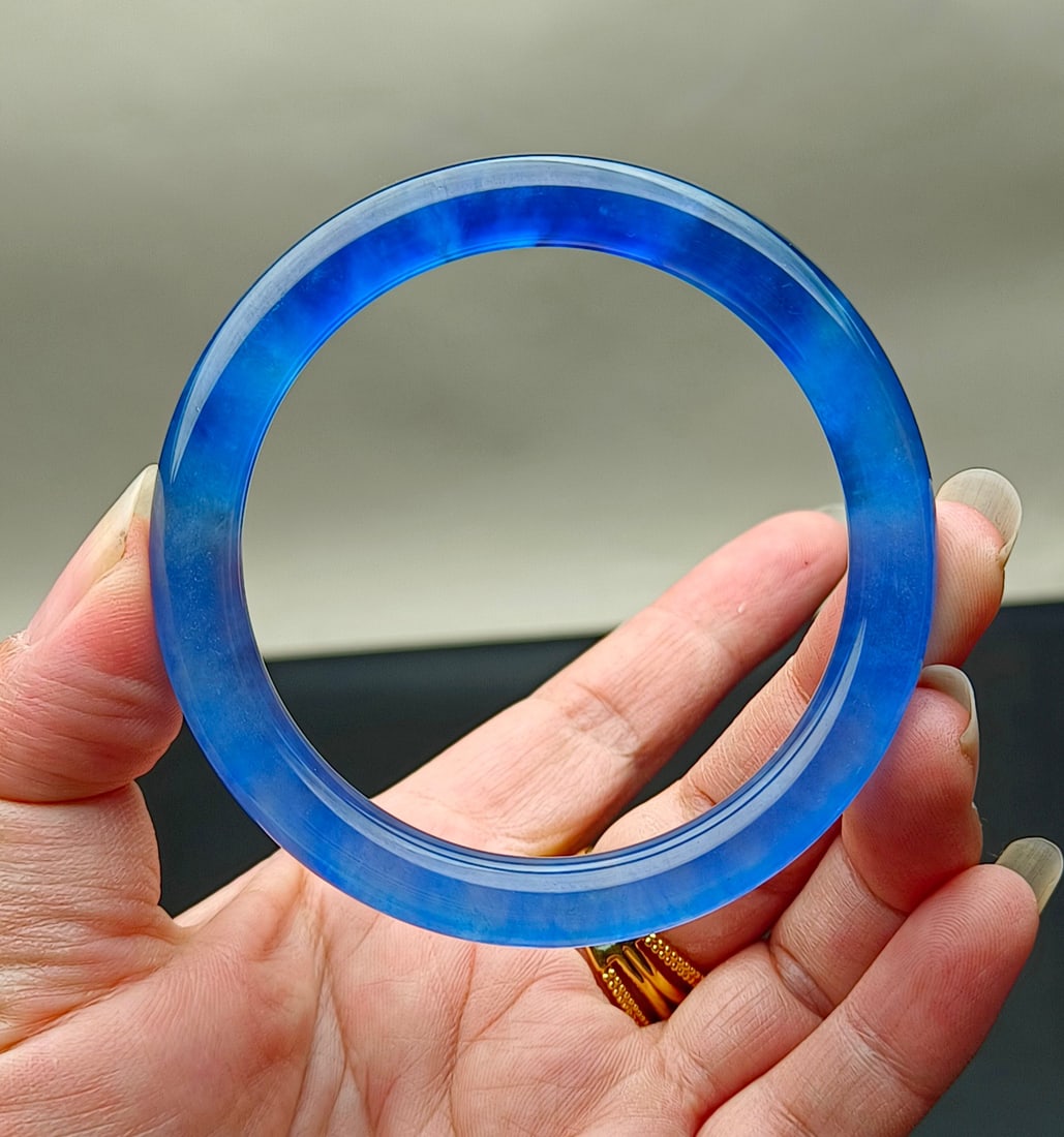 A jadeite bangle of the Dragon Stone variety with a deep blue hue.: A jadeite bangle of the Dragon Stone variety, with excellent translucency and is absolutely perfect. Provenance:Mrs. Blair, Newport Beach, California. Our dedicated team expertly handles both domestic