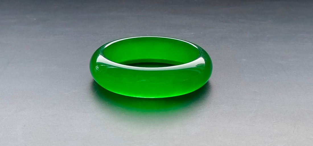 A top-grade dragon stone type imperial green flat jadeite bangle (1 of 8)