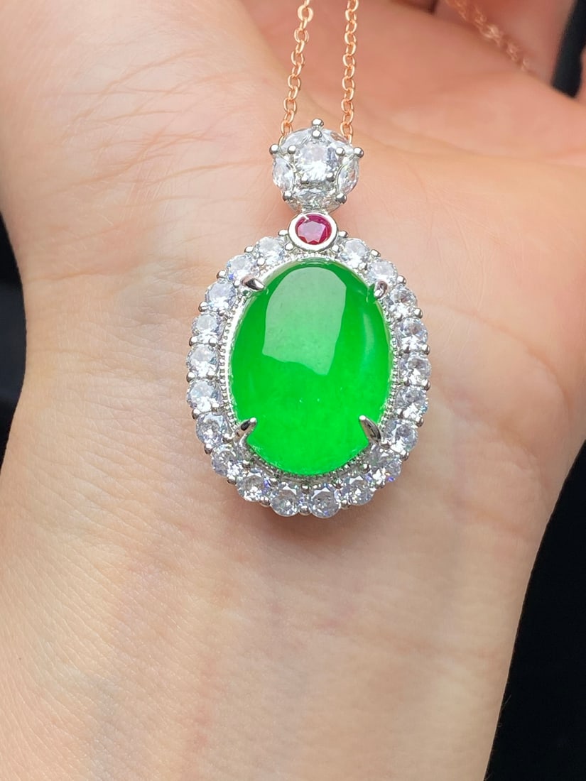 Jadeite pendant with full green icy texture and luxurious setting of cabochons: A luxurious jadeite pendant with a full green, icy texture and a lustrous, thick, and full appearance, set with cabochons. Provenance:Mrs. Amily, Washington, DC. Our dedicated team expertly handles bo
