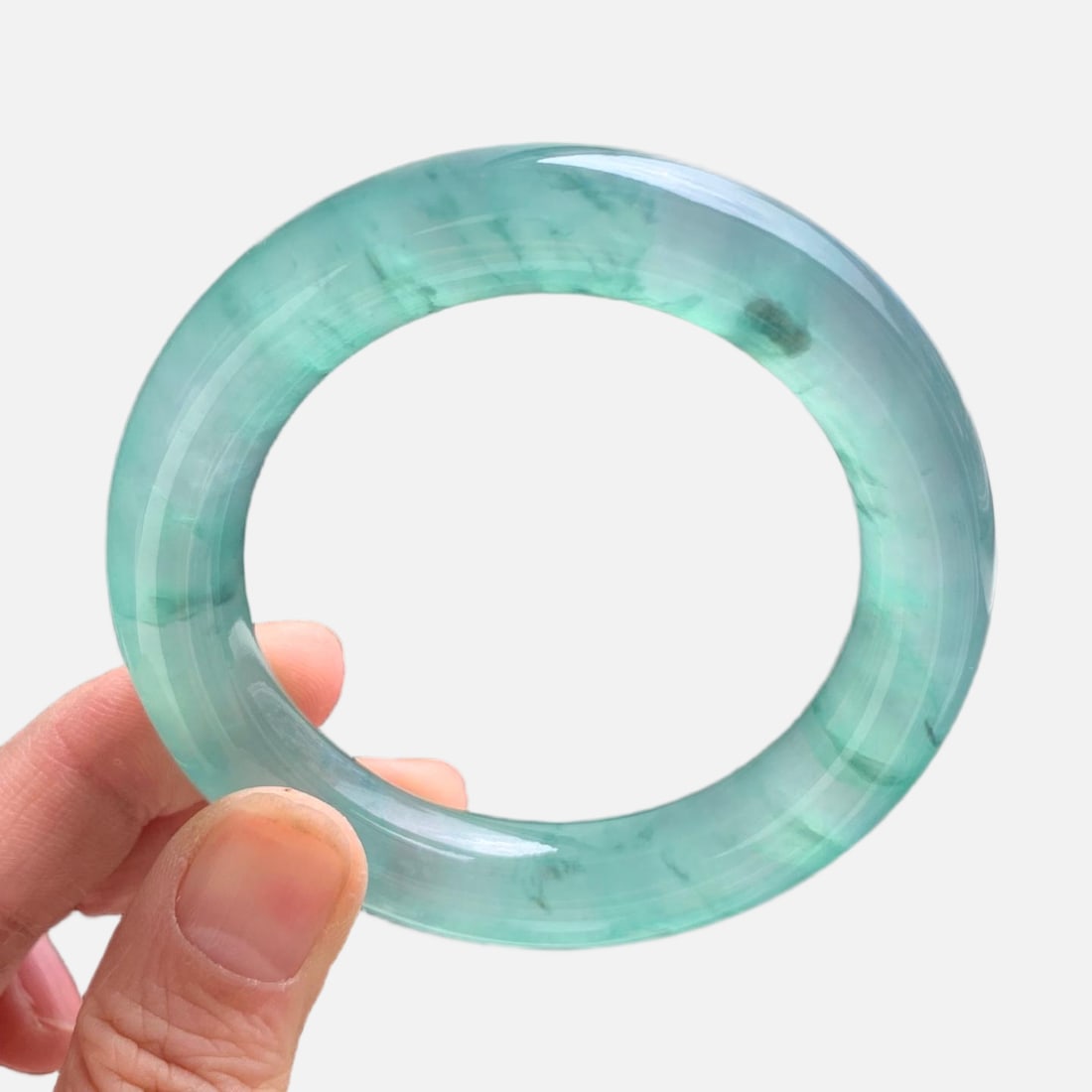 Burmese jadeite high-grade icy green with floating patterns, round bangle: This is a high-quality Burmese jadeite bangle, featuring a lake-green color with floating patterns. Made of Burmese jadeite, it is of icy quality, with fine texture and old jadeite deposits. It looks