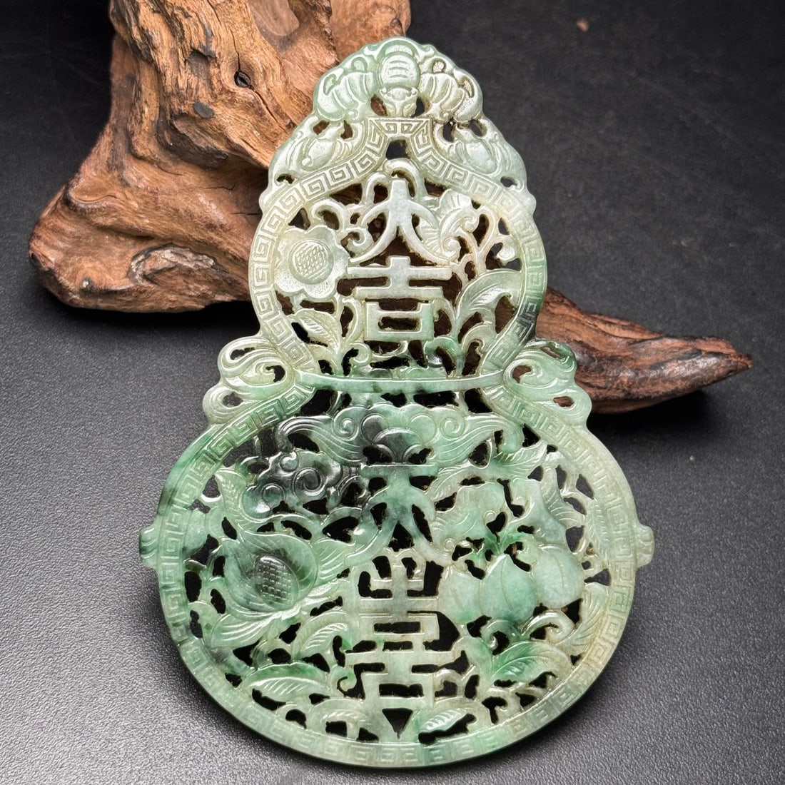 An old jade pendant in the shape of a gourd, symbolizing good fortune and peace. (1 of 9)