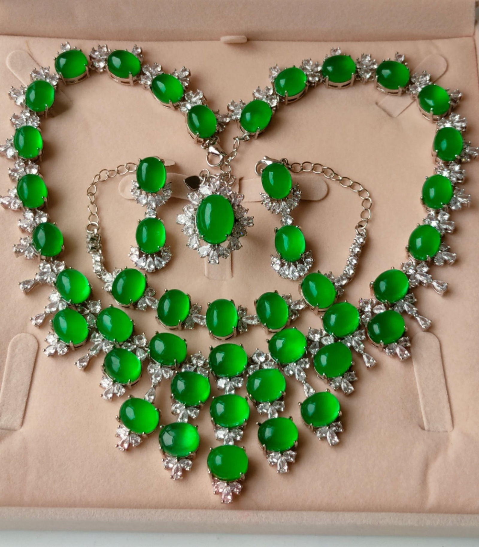 Silver set with diamonds and top-grade icy imperial green jadeite, four-piece jewelry set: This four-piece jewelry set features silver inlaid with diamonds and top-grade icy imperial green jadeite. The jadeite has excellent translucency, a delicate and pure texture without any flaws, and a