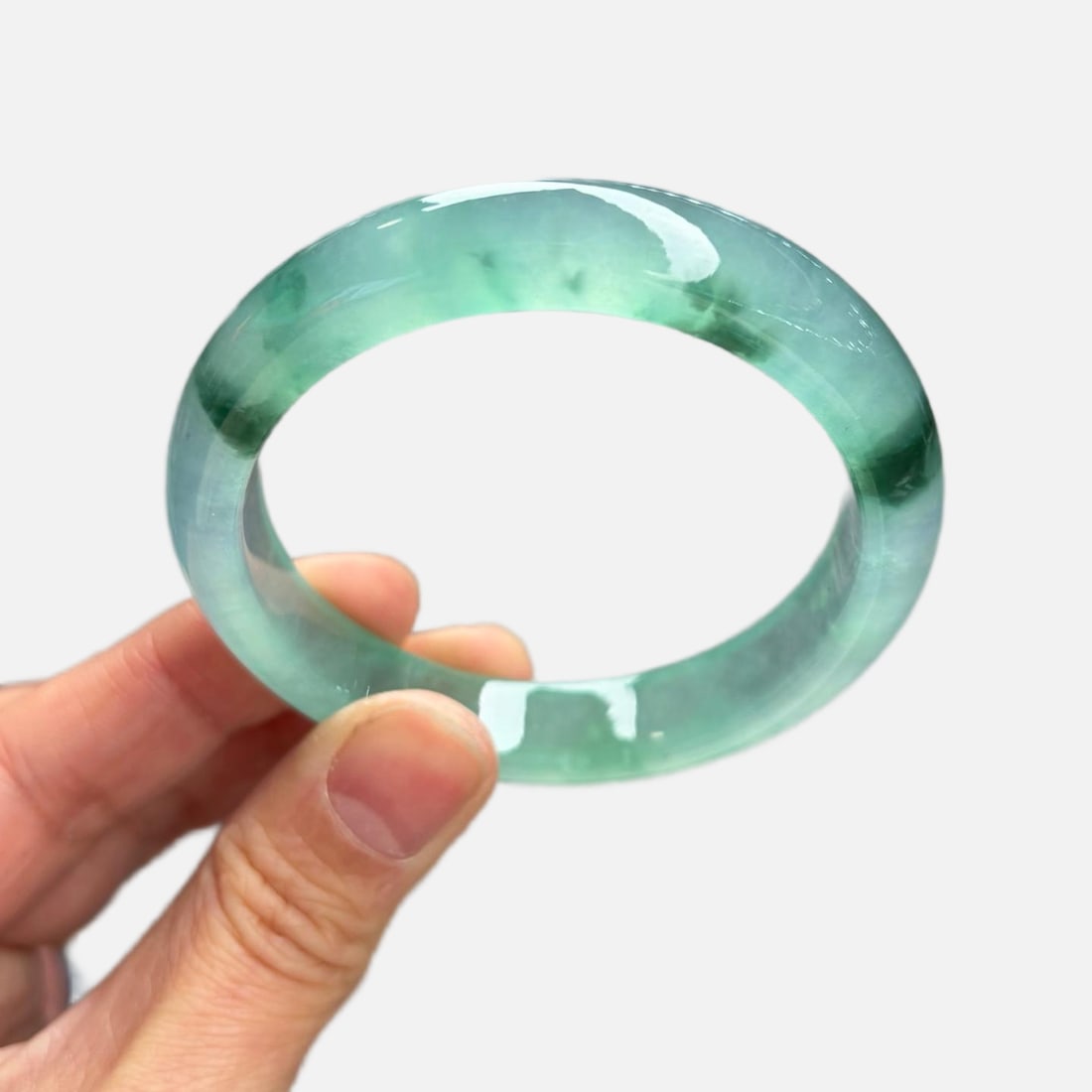Burmese jadeite bangle, high-grade icy texture, light blue color with floating patterns.: This Burmese jadeite bangle is made of high-grade icy jadeite with a light blue hue and floating patterns. The jadeite is of fine texture, old variety, and looks very beautiful on the wrist. It's a pr