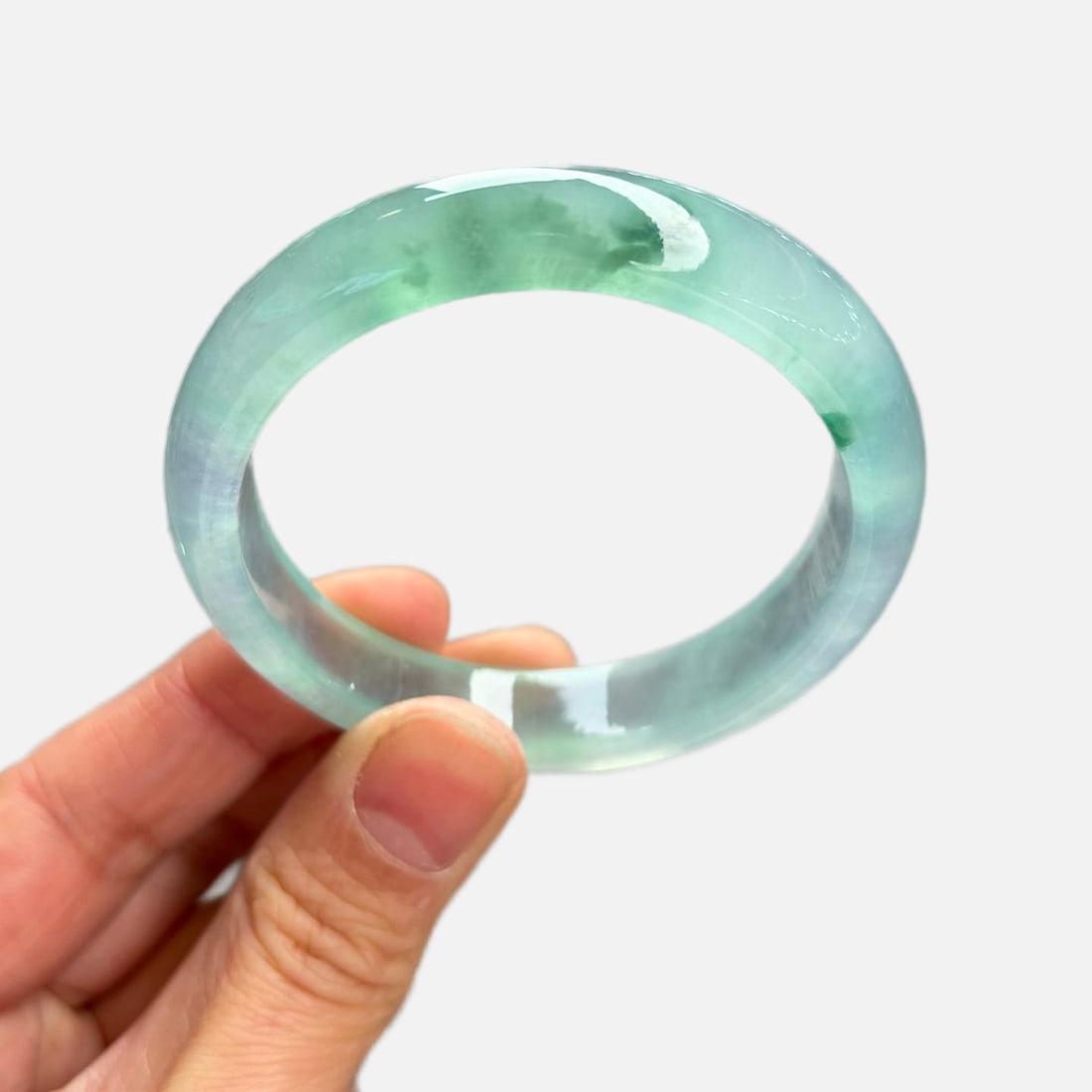 Burmese jadeite bangle, high-grade icy texture, light blue color with floating patterns.: This Burmese jadeite bangle is made of high-grade icy jadeite with a light blue hue and floating patterns. The jadeite is of fine texture, old variety, and looks very beautiful on the wrist. It's a pr