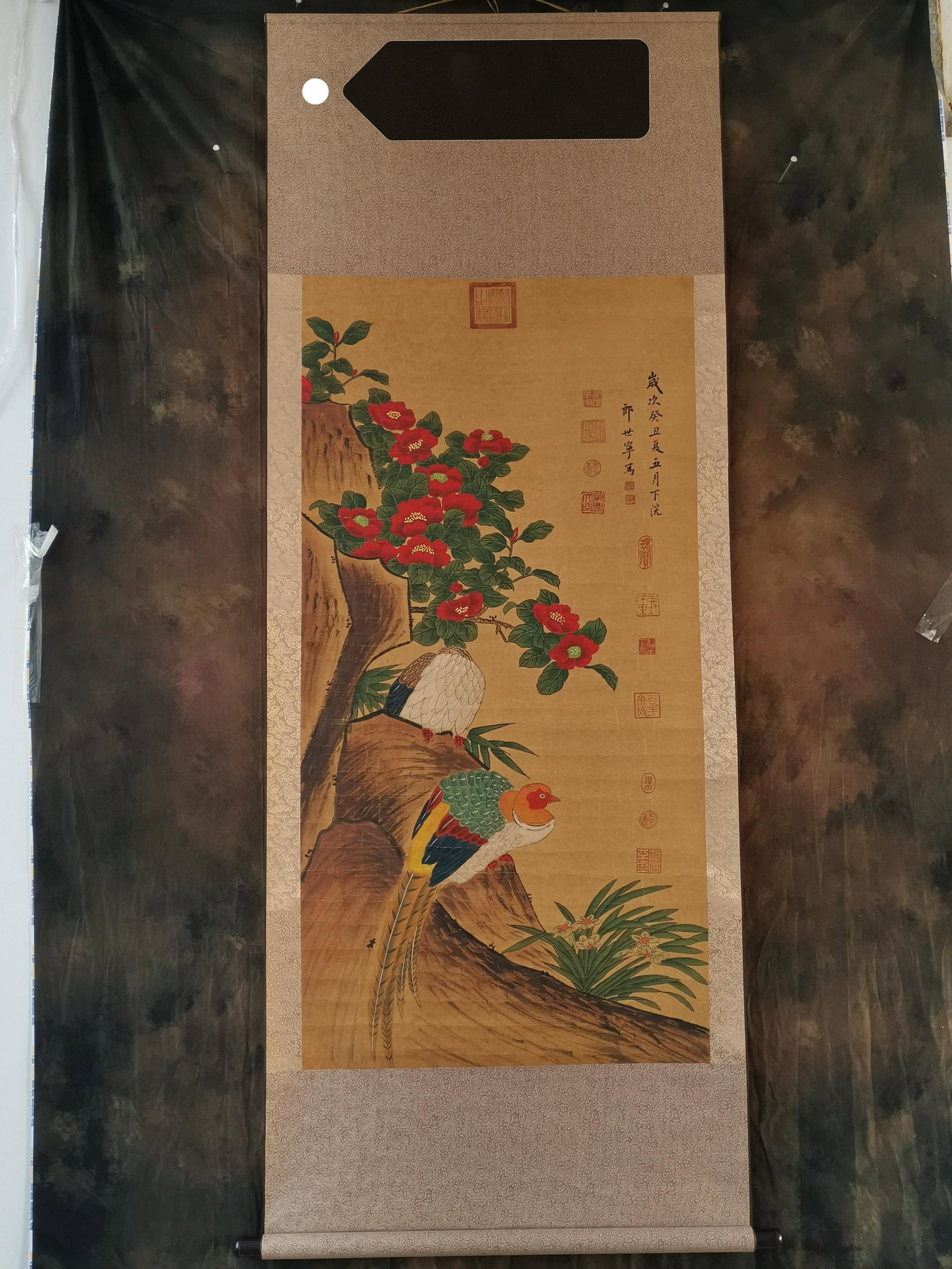 Lang Shining, hanging scroll of flowers and birds on paper: This hanging scroll of flowers and birds on paper, painted by Lang Shining (Lang Shining) of the Qing Dynasty, depicts a scene of blooming camellias and a golden pheasant perched on a rock. The brushw