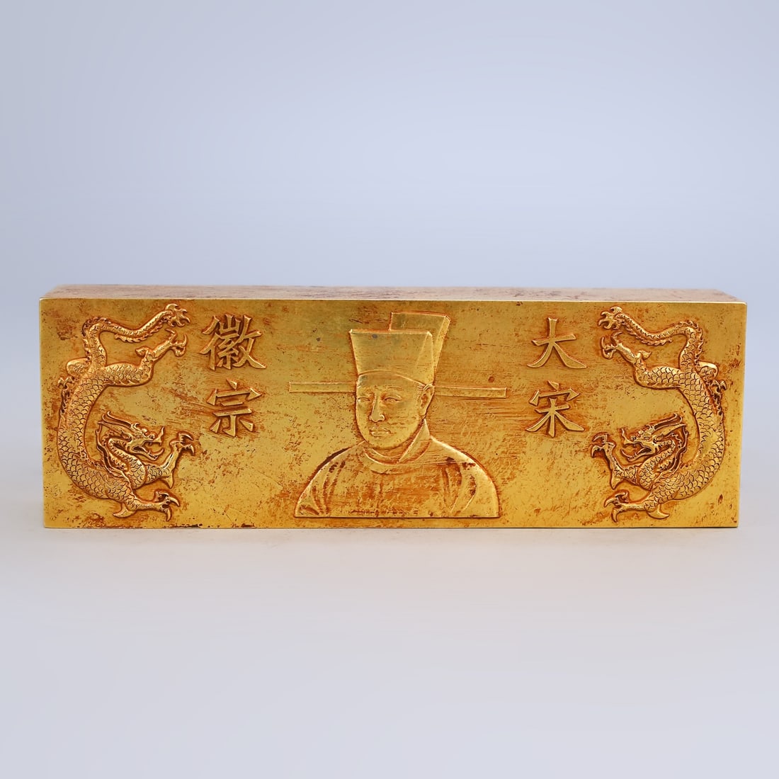A treasured gilt-copper brick, engraved with relief carvings. (1 of 10)