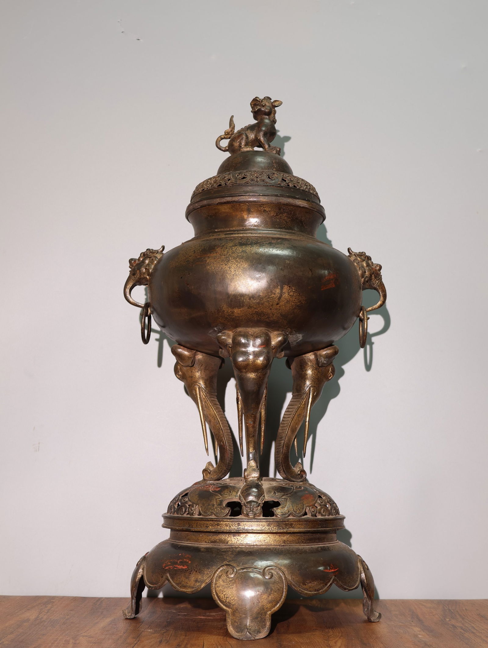 Rare pure copper gilt cinnabar incense burner with auspicious cloud and longevity patterns, three: This is a rare pure copper incense burner with gold-painted cinnabar, featuring auspicious cloud and longevity patterns, three elephant feet, auspicious beast ears, and a lion-shaped lid. It is a larg