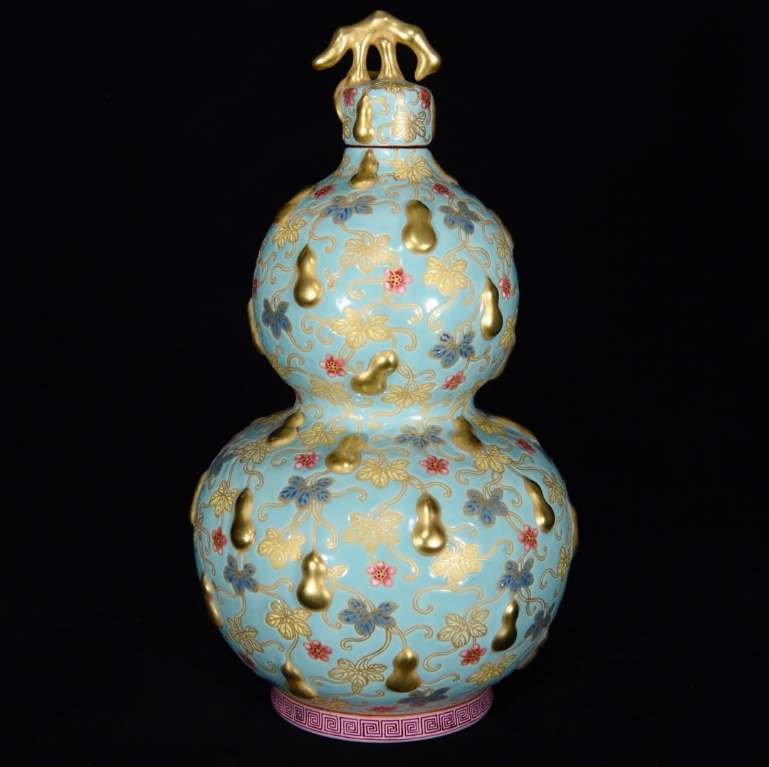 A gourd-shaped vase with enamel relief and gilt gourd design from the Qianlong period of the Qing: A Qing Dynasty Qianlong period enamel-painted gourd-shaped vase with relief and gilt gourd design, 28.5 x 16 cm. Provenance:Private collection, Vancouver, Canada. Our dedicated team expertly handles b