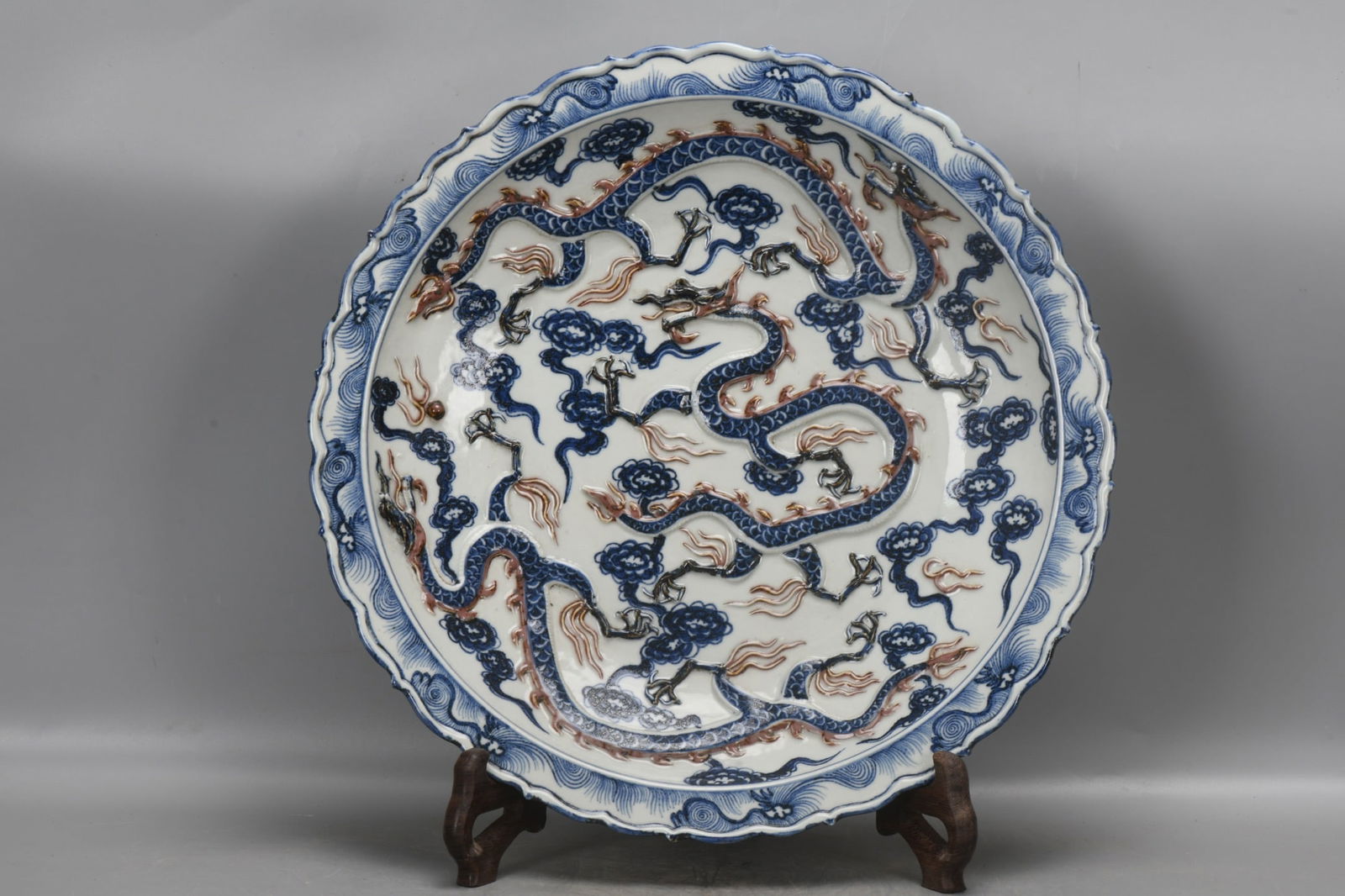 Yuan Dynasty, a blue and white underglaze red plate with three dragons in relief.: A Yuan dynasty blue and white underglaze red plate with three dragons in relief, measuring 6.5 cm in height, 44 cm in diameter at the mouth, and 26 cm in diameter at the base. Provenance:Private Estat