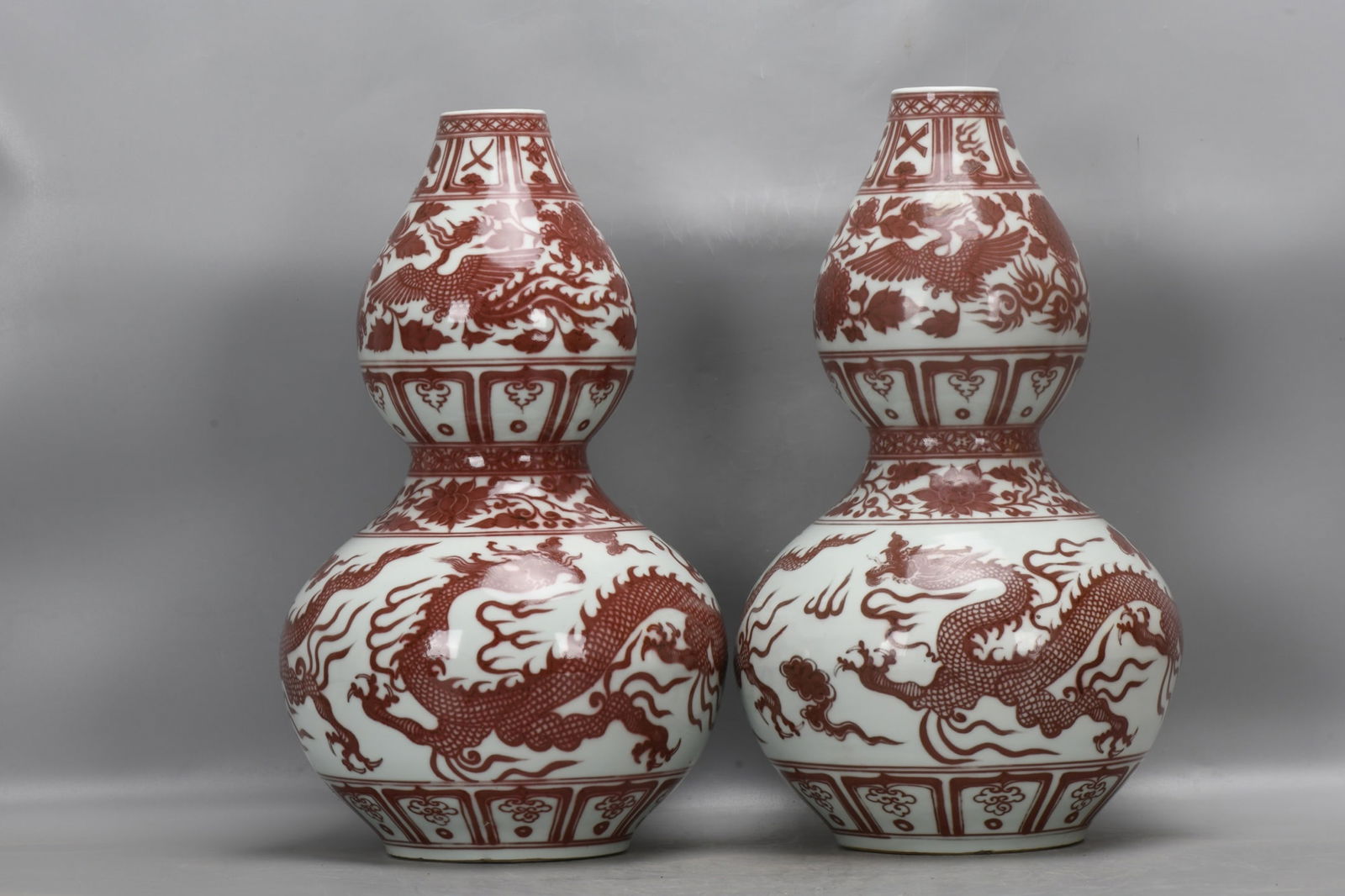 A pair of Yuan Dynasty underglaze red gourd-shaped vases with dragon and phoenix designs. (1 of 9)