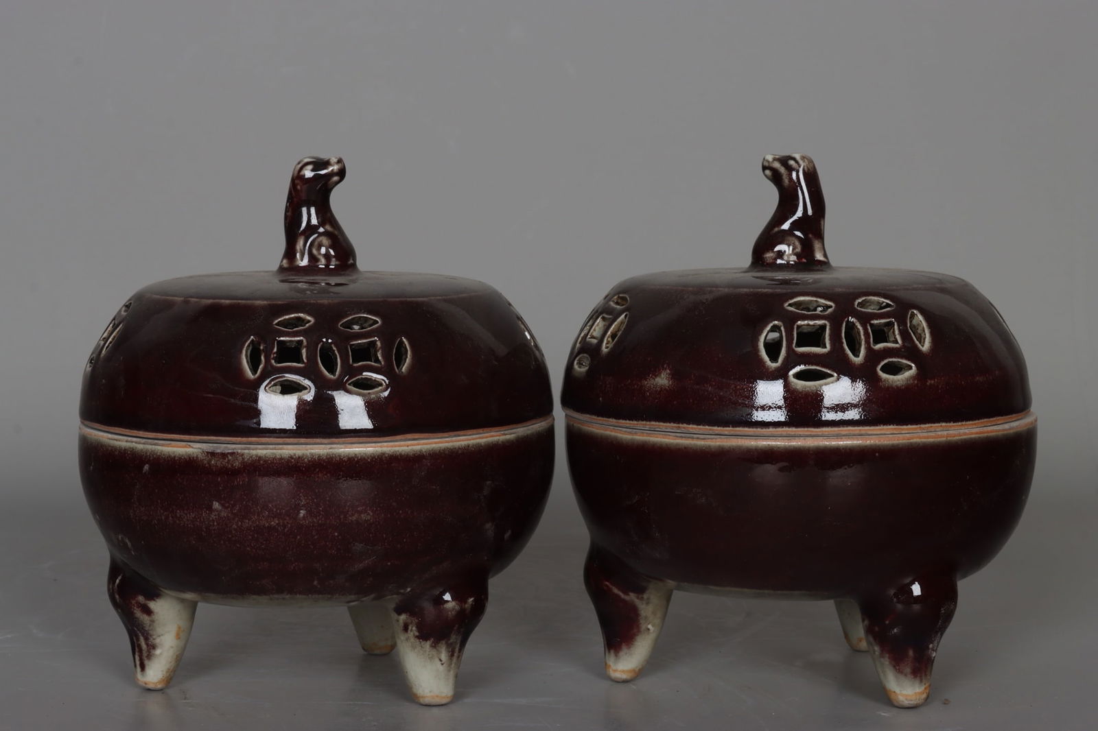 A pair of Yuan Dynasty sacrificial red openwork three-legged dog-head incense burners: A pair of Yuan Dynasty sacrificial red carved openwork three-legged dog-head incense burners, 16 cm high, 14 cm in diameter at the mouth, and 10 cm in diameter at the base. Provenance:Private collecti