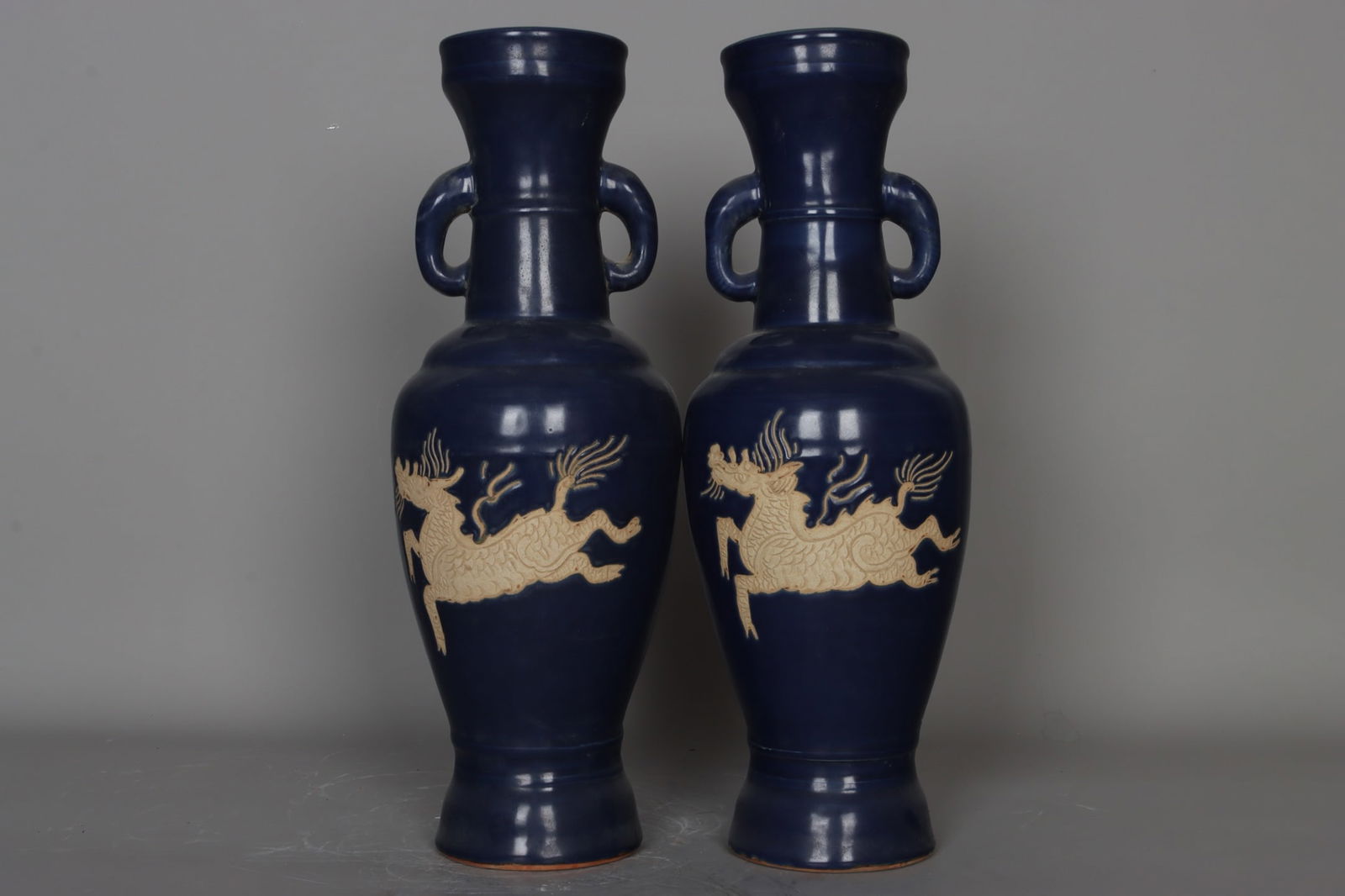 A pair of Yuan Dynasty sacrificial orchid-carved kylin elephant-ear vases: A pair of Yuan Dynasty sacrificial vases with carved qilin and elephant-ear handles, 41.5 cm high, 9.6 cm in mouth diameter, 14.8 cm in belly diameter, and 10.7 cm in base diameter. Provenance:Private
