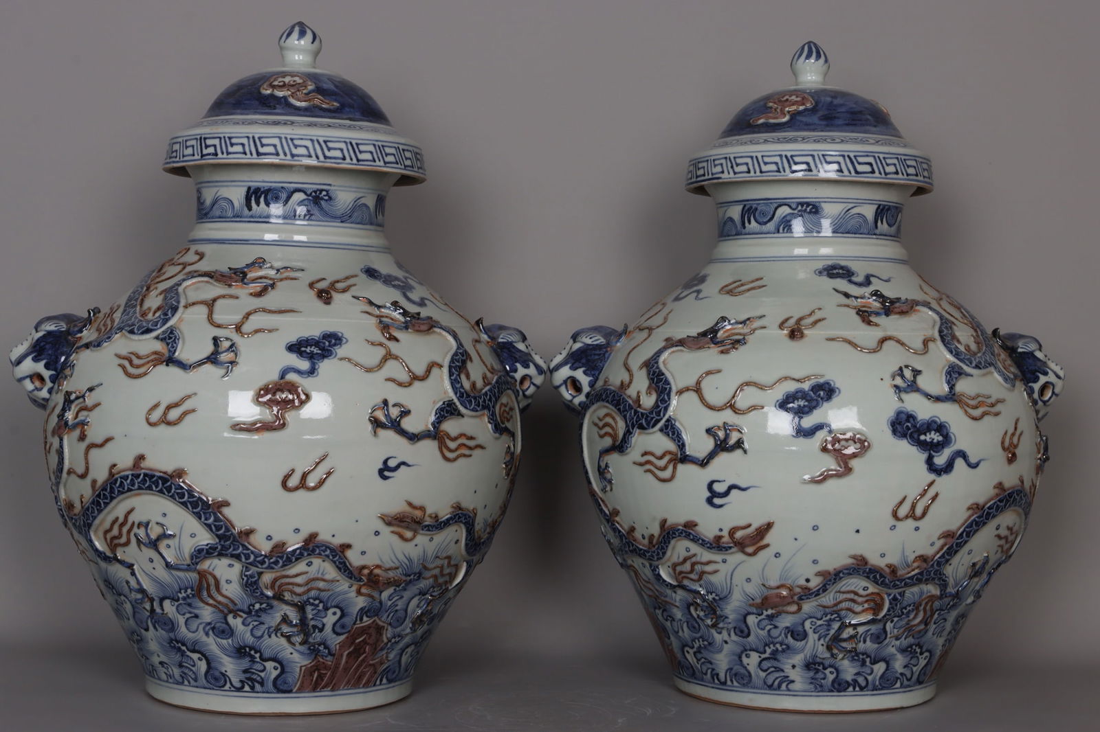 A pair of Yuan dynasty blue-and-white underglaze red carved five-dragon cloud-patterned animal head: A pair of Yuan dynasty blue-and-white underglaze red carved five-dragon cloud-patterned animal-head jars, 55 cm high, 17.5 cm in mouth diameter, 42 cm in belly diameter, and 21 cm in base diameter. Pr