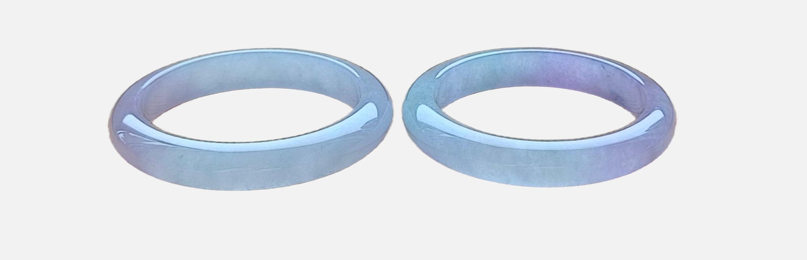 A pair of top-grade dragon stone type flat strip jadeite bracelets with spring colors: pair of top-grade dragon stone jadeite bangles, flat and strip-shaped with spring-like colors, excellent translucency, absolutely perfect. Provenance:Private collection, Middletown, Rhode Island. Our