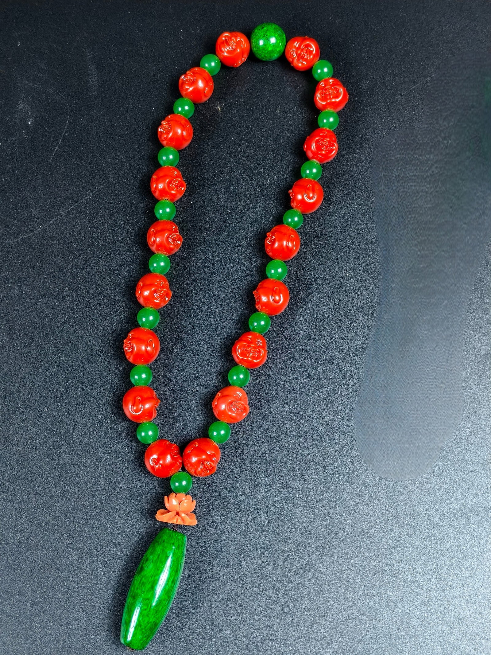 A string of coral Maitreya Buddha prayer beads (1 of 9)