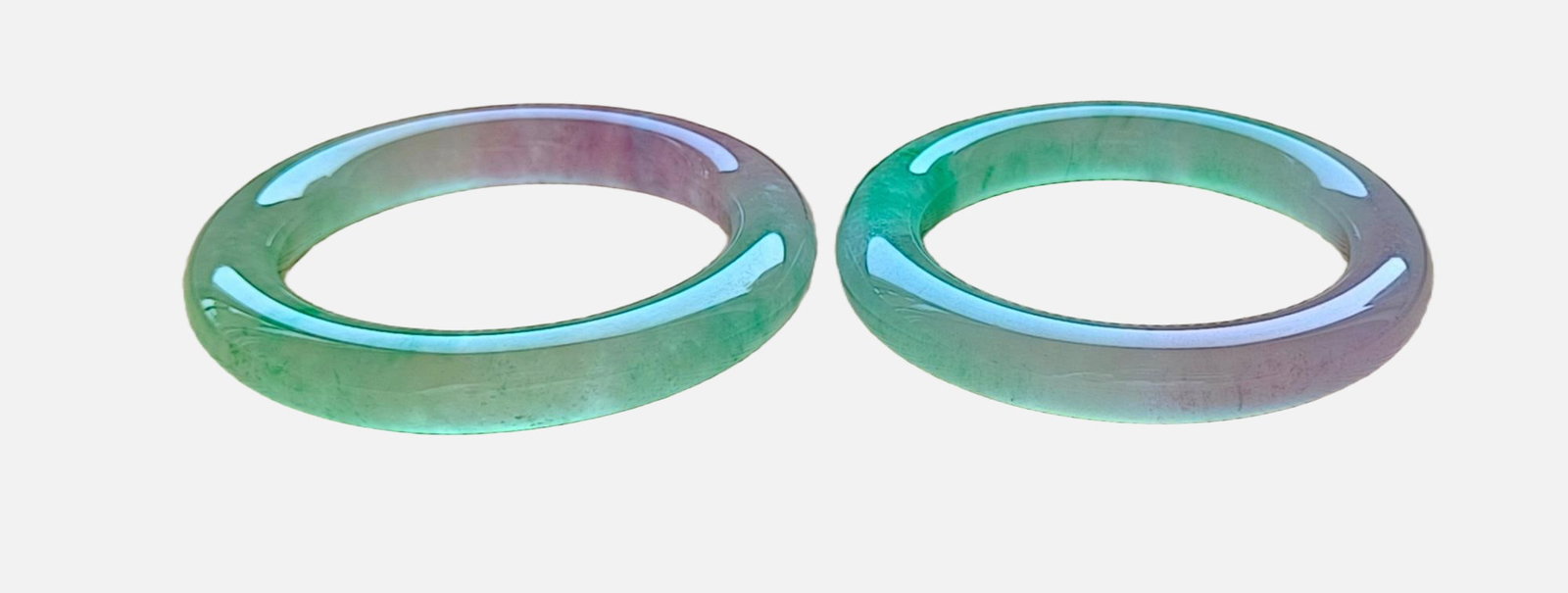 A pair of top-grade glass-type jadeite bangles with spring colors: A pair of top-grade glass-type jadeite bangles with spring colors, excellent translucency, absolutely perfect, and can withstand ultraviolet light. Provenance:Private collection from a professor in Ma