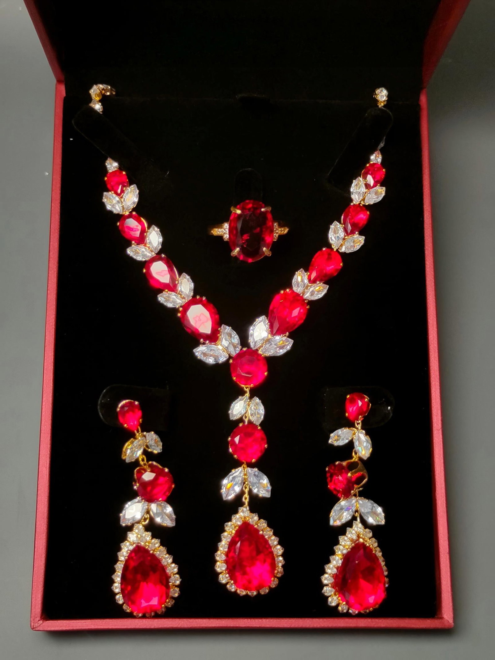 Silver-gilt four-piece jewelry set inlaid with diamonds and gemstones: This four-piece silver-gilt jewelry set, inlaid with diamonds and gemstones, is crystal clear and dazzling, exquisitely carved, and exudes a grand presence. The ring face measures 1.8 x 1.3 cm. Proven