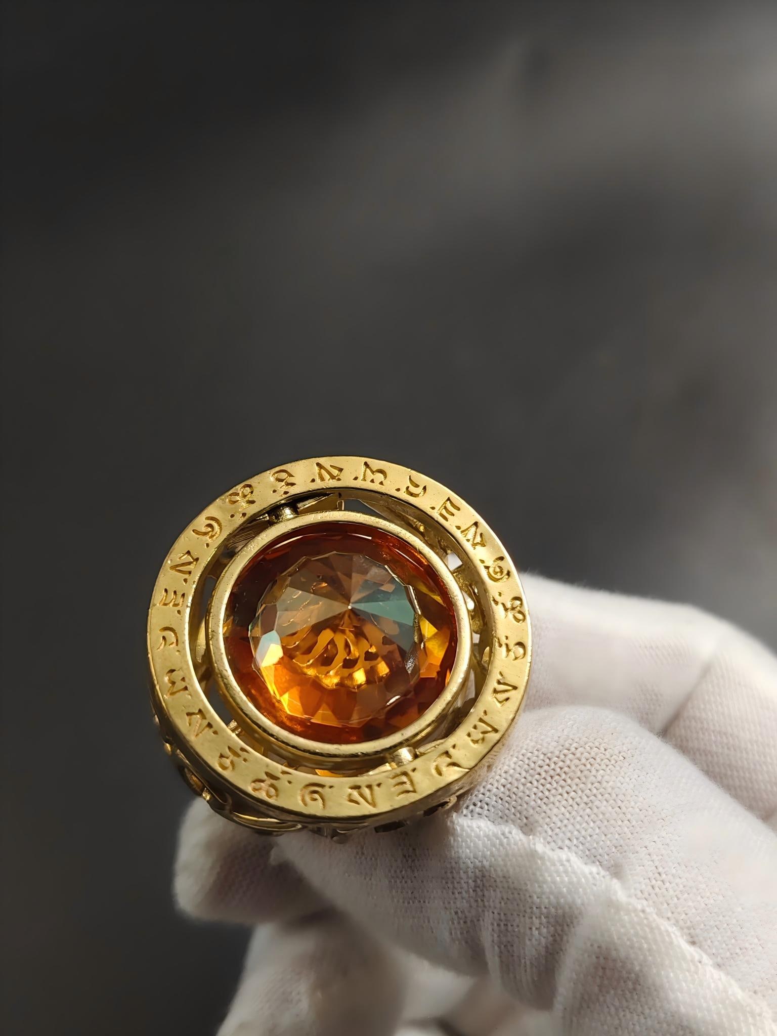 Gilded bronze ring inlaid with yellow gemstones: This gilt bronze ring, inlaid with yellow gemstones, features a shimmering gold face adorned with mysterious, rotating patterns. It measures 2.2cm in diameter, 2.0cm in face diameter, and weighs 32.4g