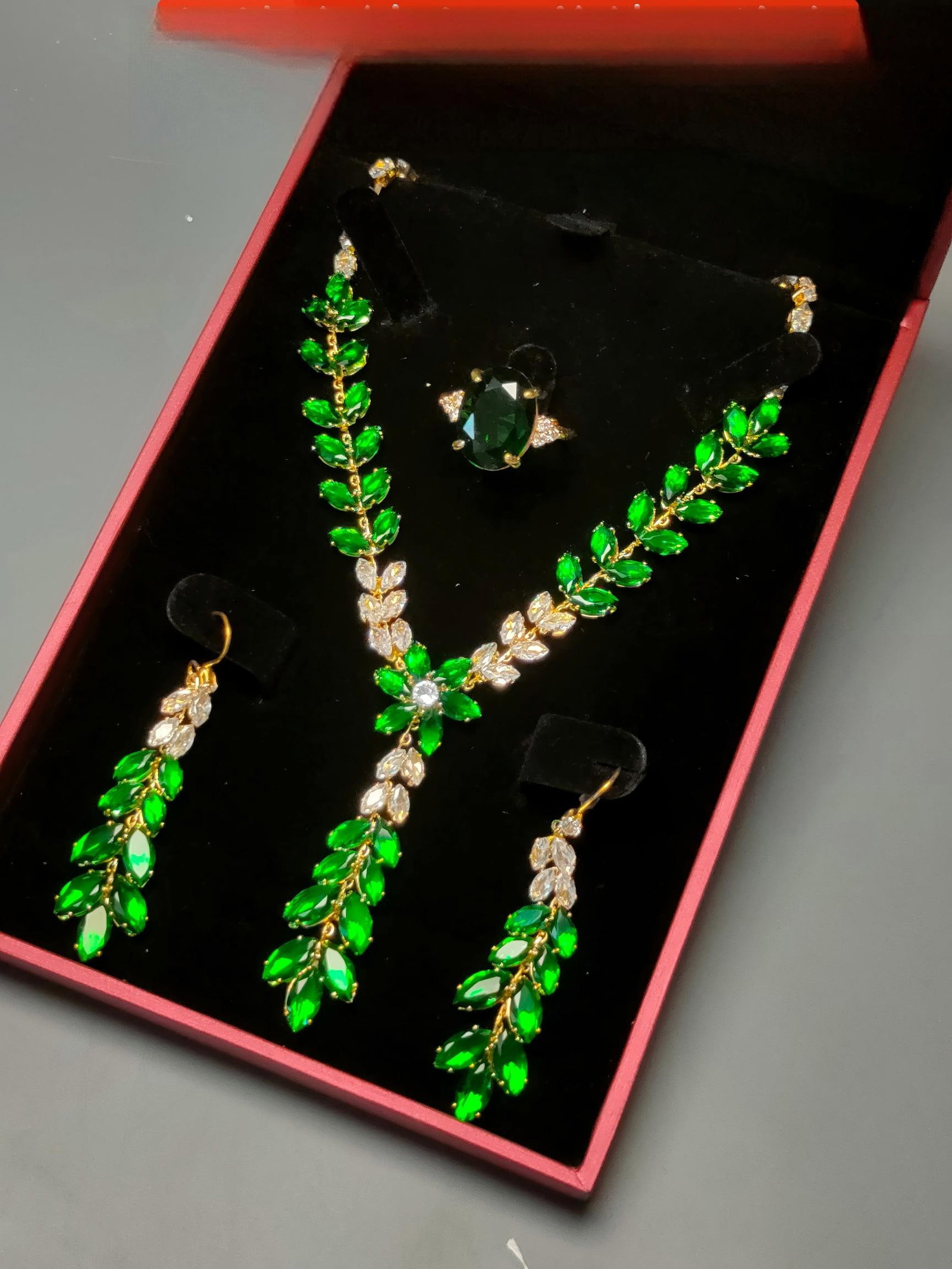 Silver-gilt gemstone jewelry four-piece set: This four-piece silver-gilt jewelry set, inlaid with gemstones, is crystal clear and dazzling, exquisitely carved, and exudes a grand presence. The ring face size is 1.6 x 1.2 cm. Provenance:Private c