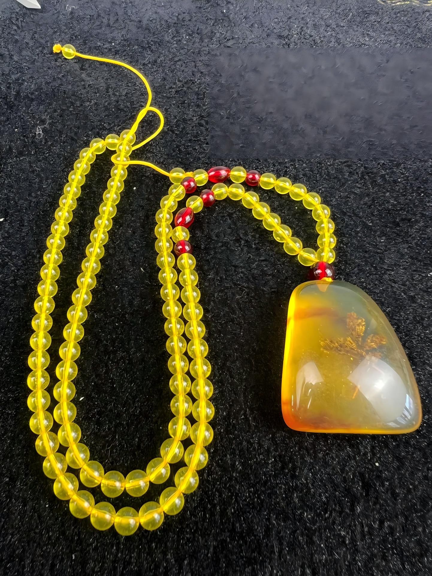 Amber Pendant: The amber pendant has a smooth, oily texture, pure color, and a warm, smooth feel. It is 36cm long, 45x37mm in size, and weighs 35g. Provenance:Private collection of the retired lawyer Mr.Henry, Chelm