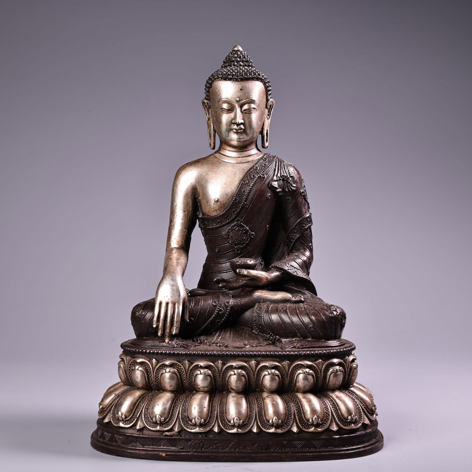 A Tibetan Buddhist statue of Shakyamuni Buddha, crafted from pure copper with high relief engraving: Nepalese-made, pure copper, high-relief engraved silver Shakyamuni Buddha statue, a Tibetan Buddhist image. Exquisite craftsmanship and beautiful design. Weighs 900 grams, 22 cm high, and 14 cm wide.