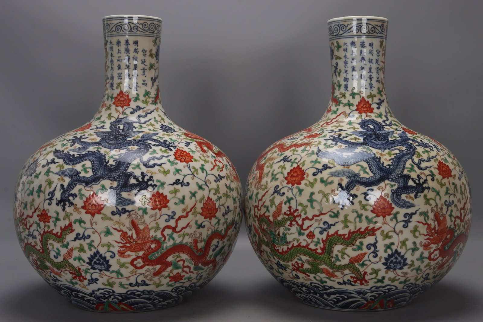 A pair of Yongle period polychrome celestial globe vases with nine dragons and flowers from the Ming: A pair of polychrome celestial globe vases with nine dragons amidst flowers from the Yongle period of the Ming Dynasty, each measuring 42 cm in height, 8.5 cm in mouth diameter, 33 cm in belly diamete