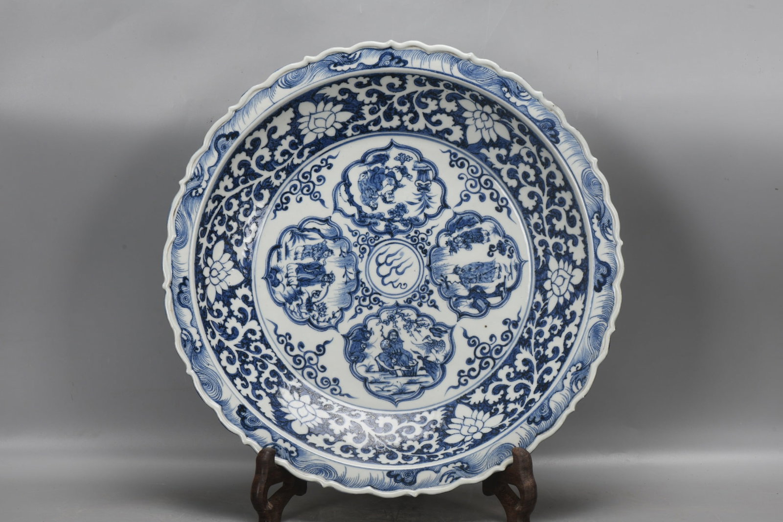 A Yuan Dynasty blue and white porcelain plate with a lotus scroll design and four auspicious motifs. (1 of 9)