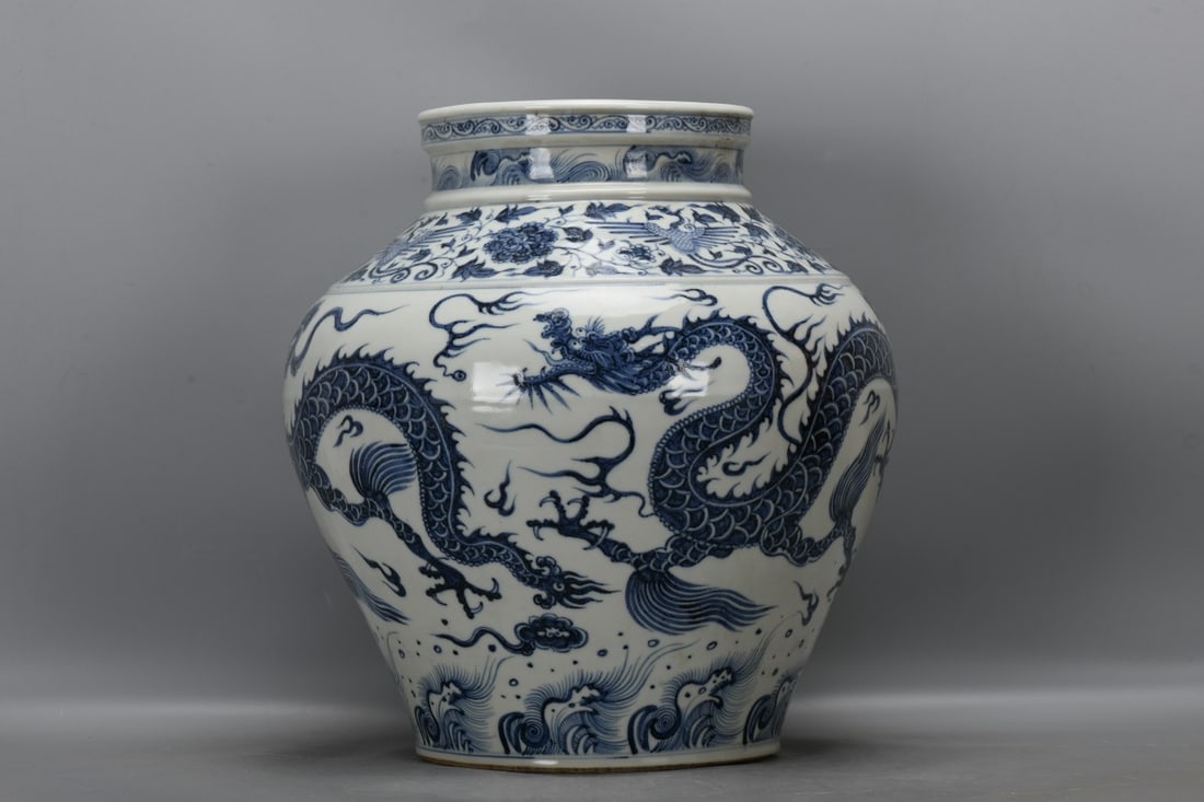 A Yuan Dynasty blue and white porcelain jar with a phoenix and dragon design amidst lotus scrolls. (1 of 8)