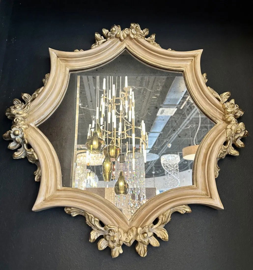 Pair of Antique mirrors: This pair of antique mirrors features hand-carved wooden frames with flower details. These mirrors in antique gold have a unique shape and design that really makes them stand out. Size: 61 x 7 x 61cm