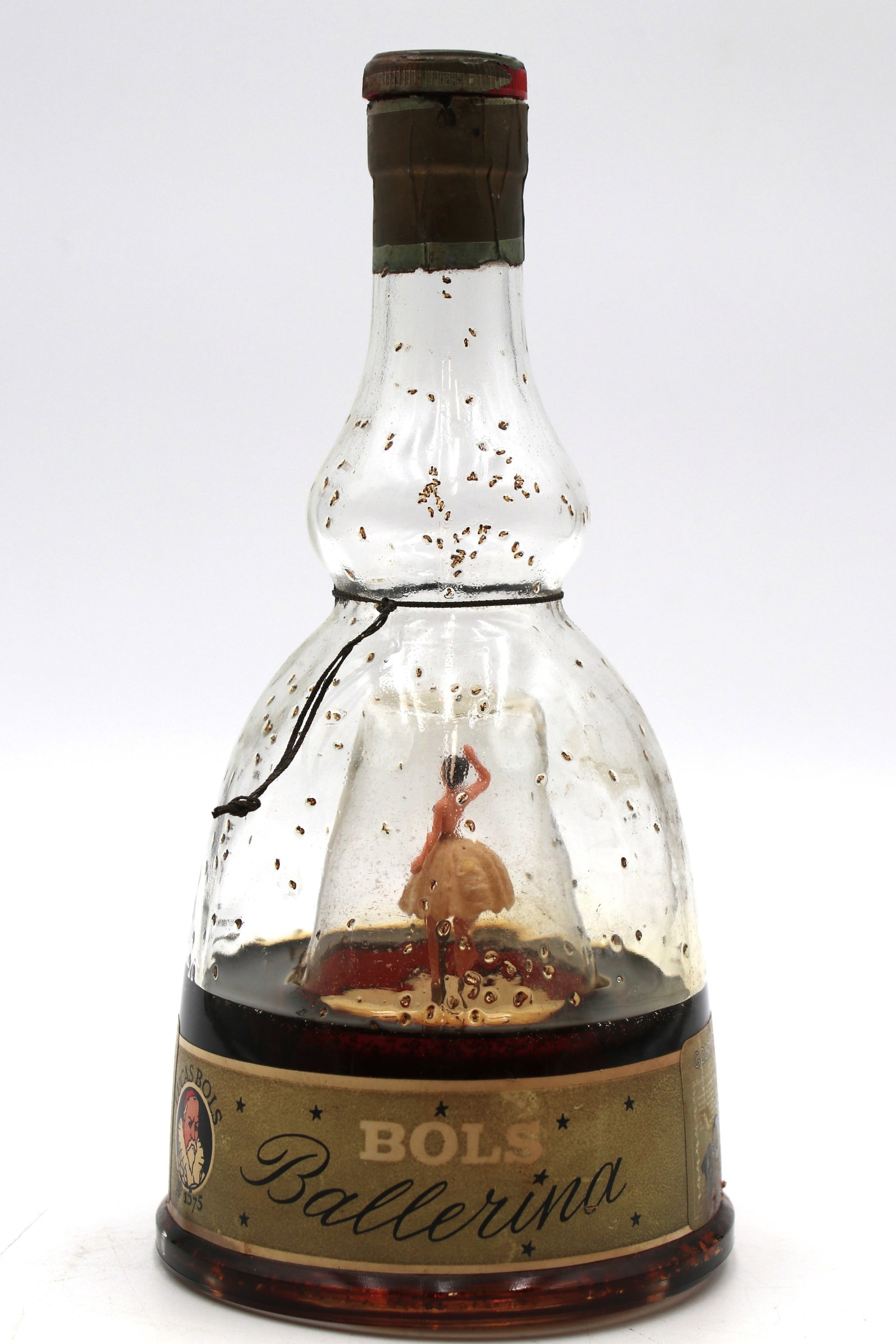 Vintage and rare bottle of Bols Ballerina Gold Liquer. AW: Vintage and rare bottle of Bols Ballerina Gold Liquer from the 60s. Comes with a ballerina on the inside that is wearing s white dress and a mechanism that spins here when moved.