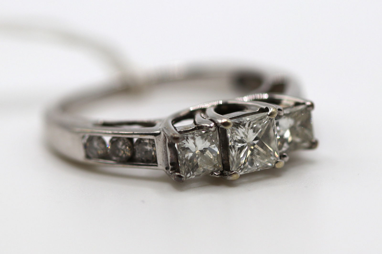 14k White Gold 3.8 gram ring with 3 Princess cut and 6 round diamonds on the sides with 1.2ctw: White Gold ring with 3 Princess cut diamonds in the center(prong set) and 6 round diamonds on the sides ( 3 per each side) with 1.2ctw. Size 8 1/4