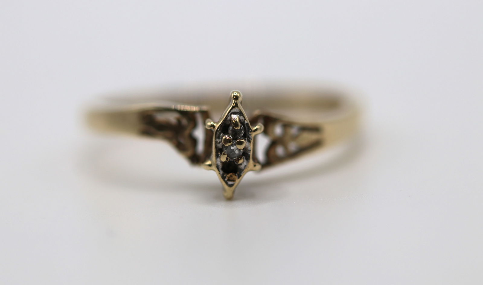 10K 1.4 gram Gold Ring with Marquise 0.02ct diamond: 10K Yellow Gold Ring with Marquise shaped center bezel with with 0.02ct diamonds. The center bezel is surrounded by beautiful laser cut from both sides. Prong set. Size 6. Engraved JED 10KP. 1.4 gram