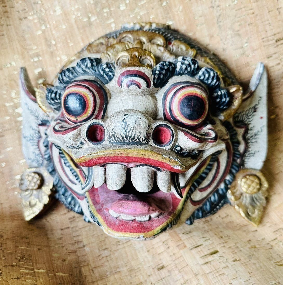 Indonesian Carved and Painted Wooden Mask: Indonesian Carved and Painted Wooden Mask. Late 19th or early 20th century, carved wooden mask with bulging eyes, large open mouth with sharp teeth, painted in vivid colors and gilt. Dimensions: 8H ? 